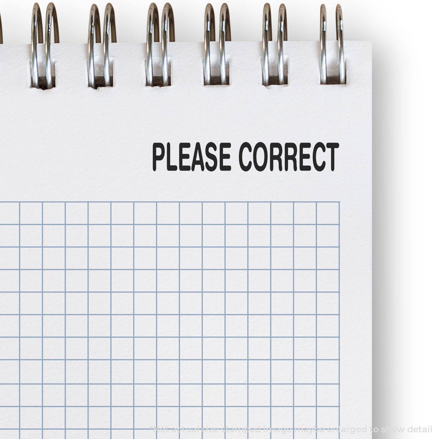 A notebook with a grid pattern and a Large Please Correct Rubber Stamp imprint on the top of the page.