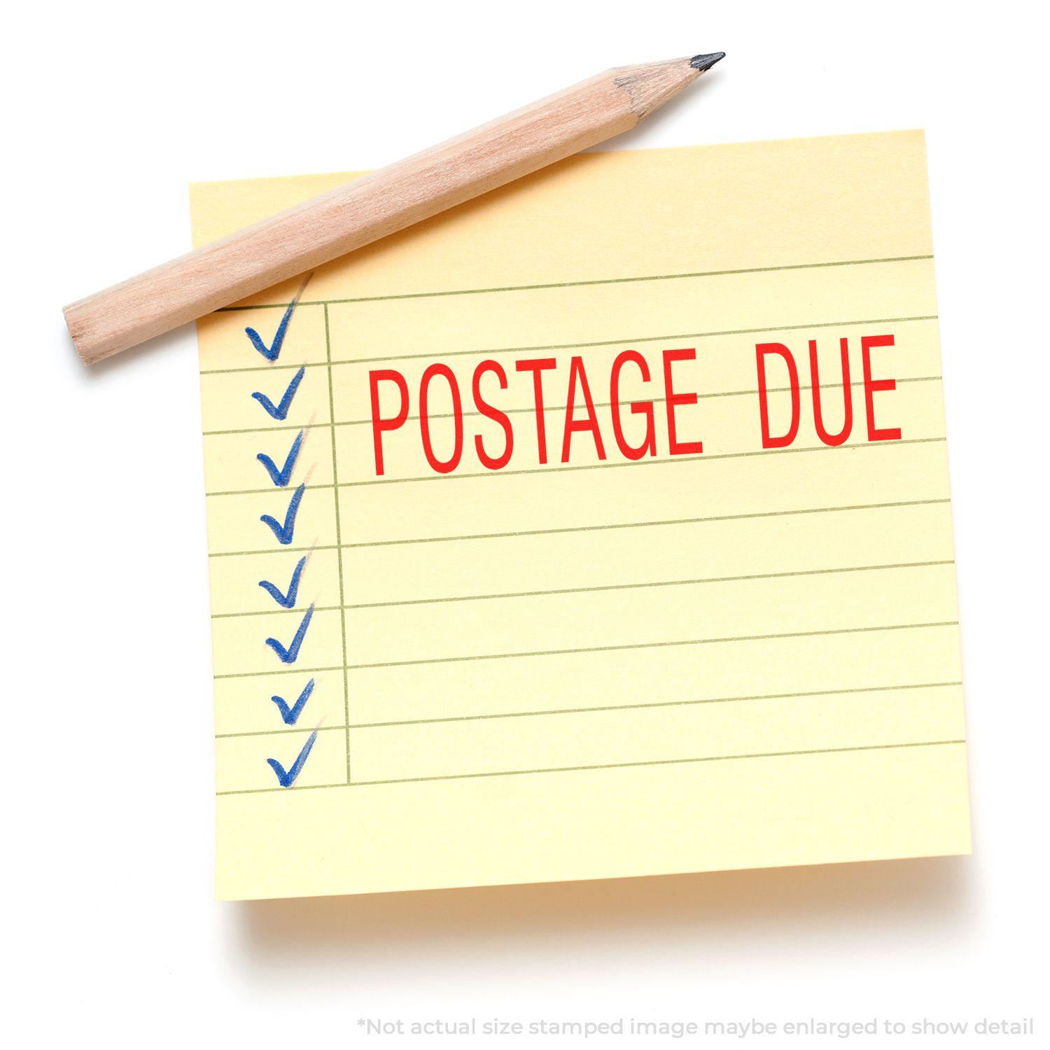 Yellow sticky note with POSTAGE DUE stamped in red using a Slim Pre-Inked Postage Due Stamp, next to a pencil.