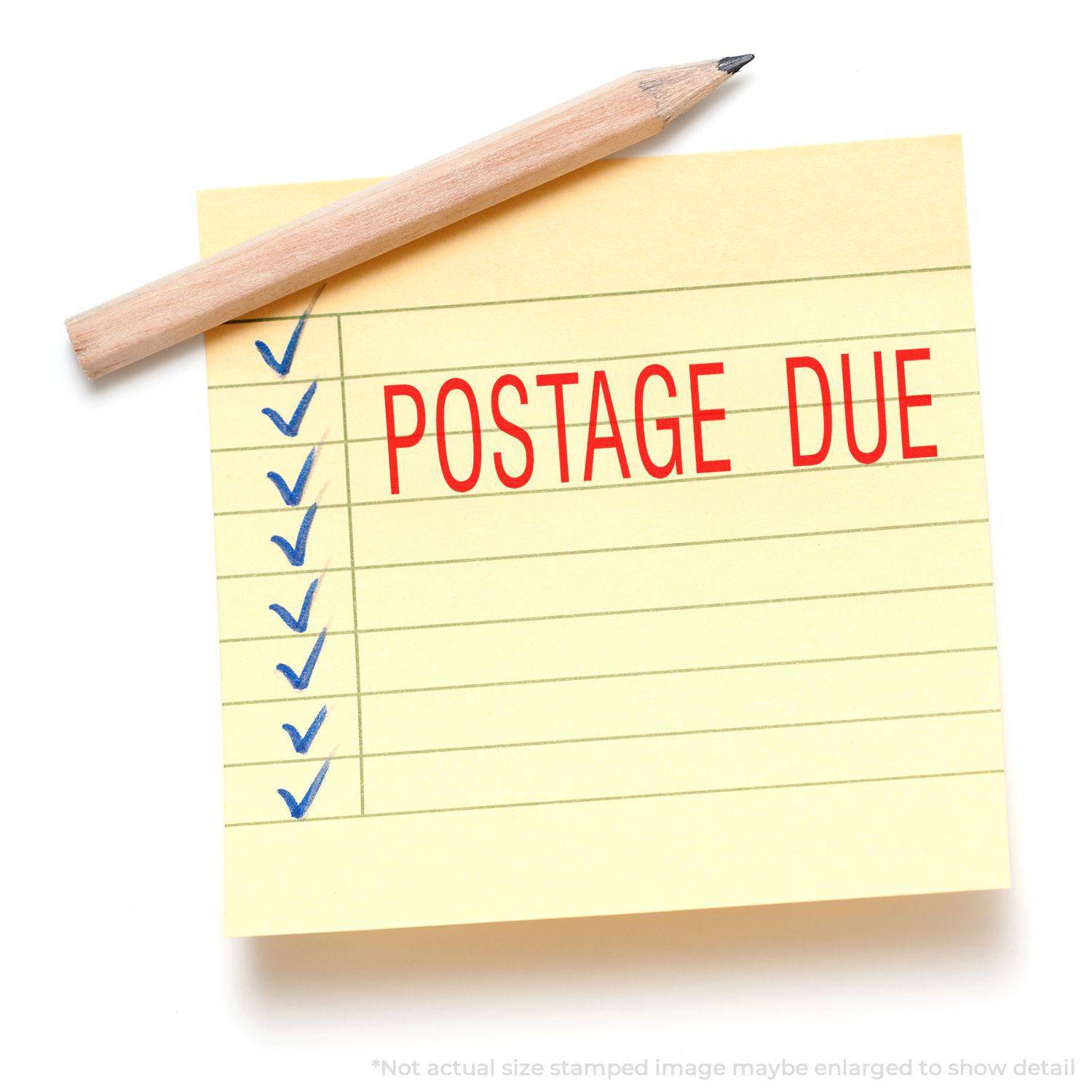 Yellow sticky note with blue checkmarks and POSTAGE DUE stamped in red using the Large Pre-Inked Postage Due Stamp, pencil on top.