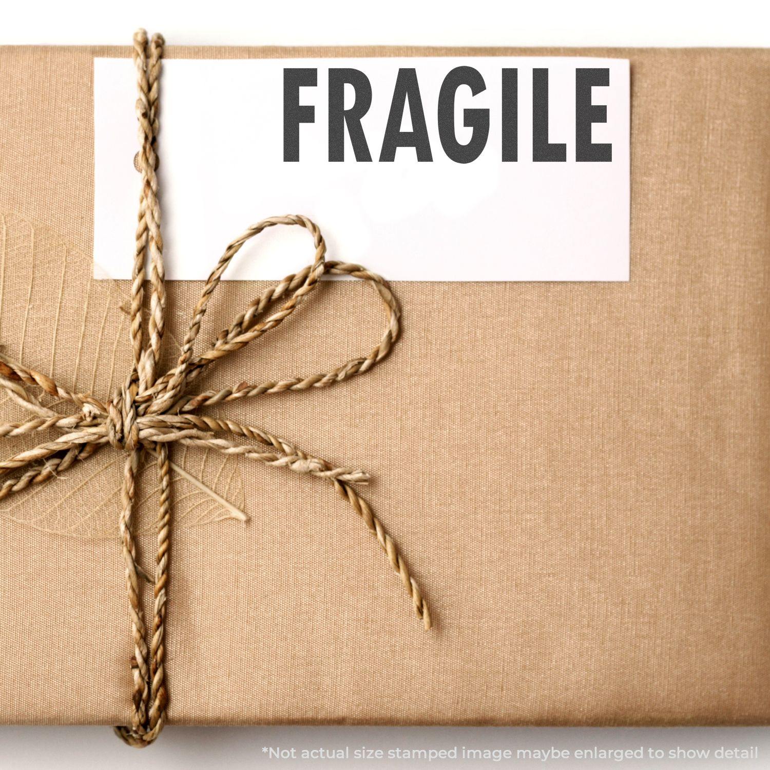 A brown package with a Large Self Inking Fragile Stamp marking FRAGILE on a white label, tied with a brown rope.