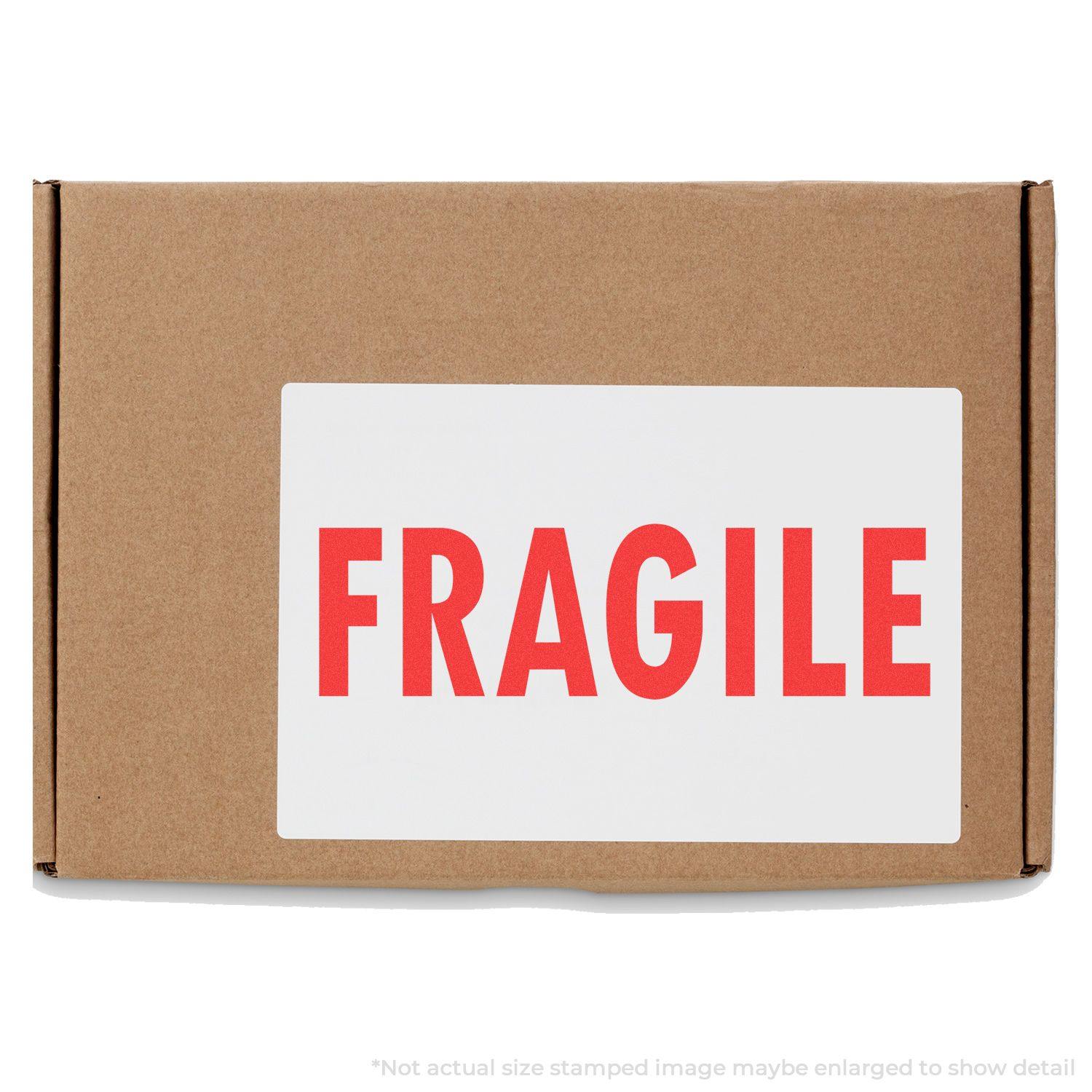 Brown cardboard box with a large white label displaying FRAGILE in bold red letters, indicating a fragile rubber stamp marking.