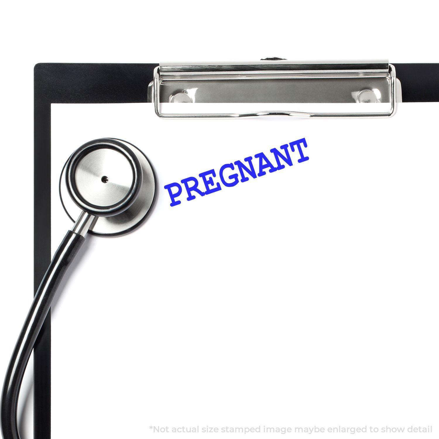 A stethoscope and clipboard with the word PREGNANT stamped in blue using the Large Pregnant Rubber Stamp.