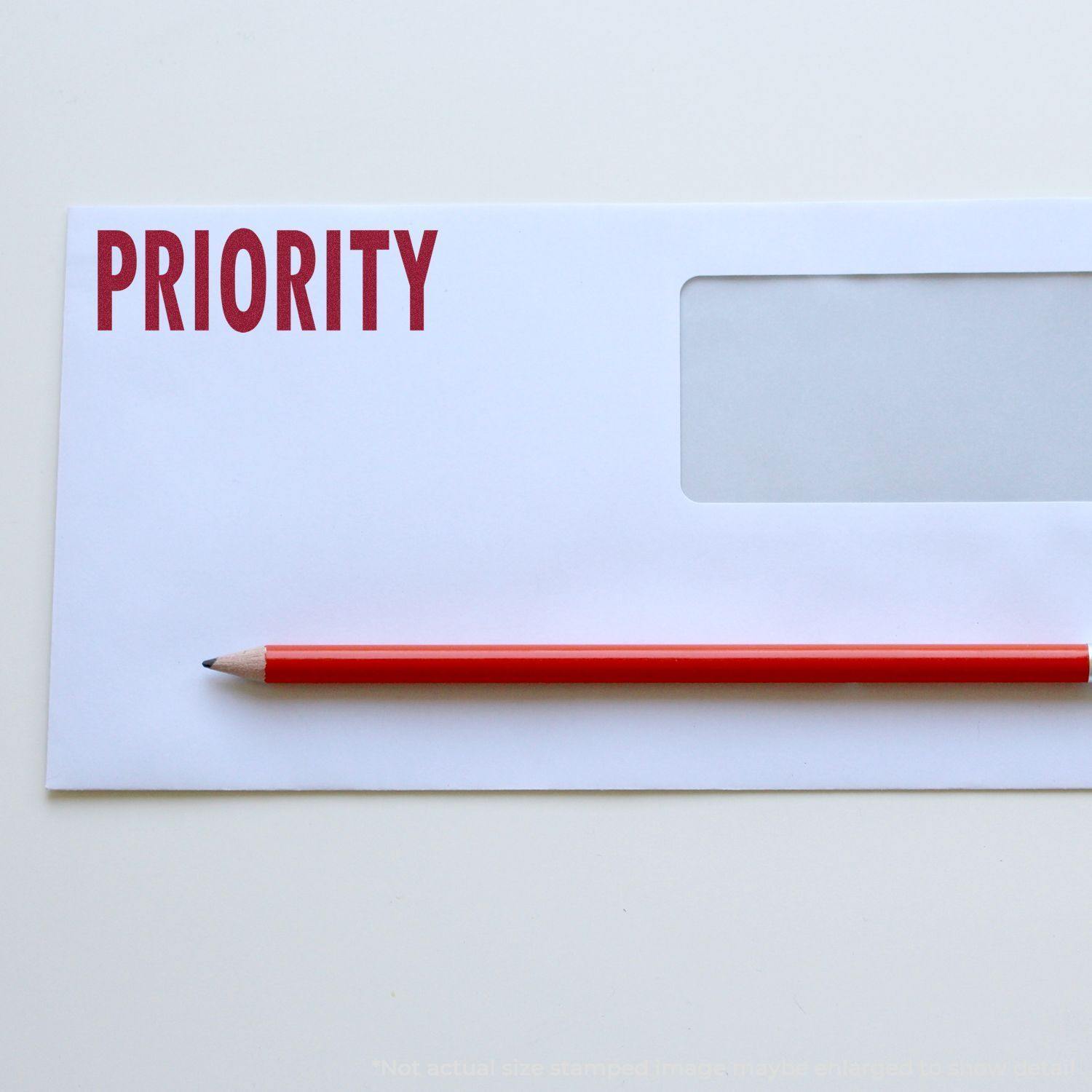 A stock office rubber stamp with a stamped image showing how the text "PRIORITY" in a large font is displayed after stamping.