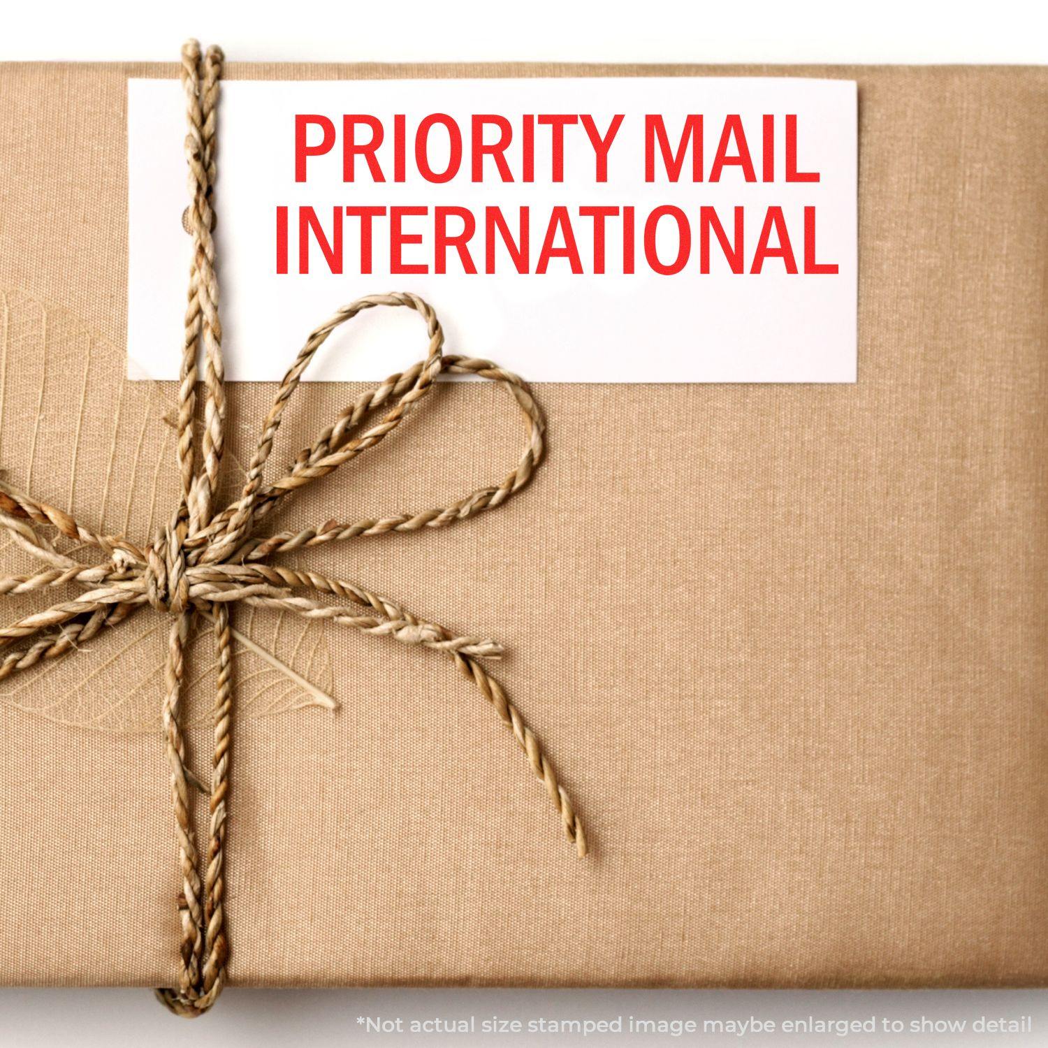 A stock office rubber stamp with a stamped image showing how the text "PRIORITY MAIL INTERNATIONAL" in a large font is displayed after stamping.