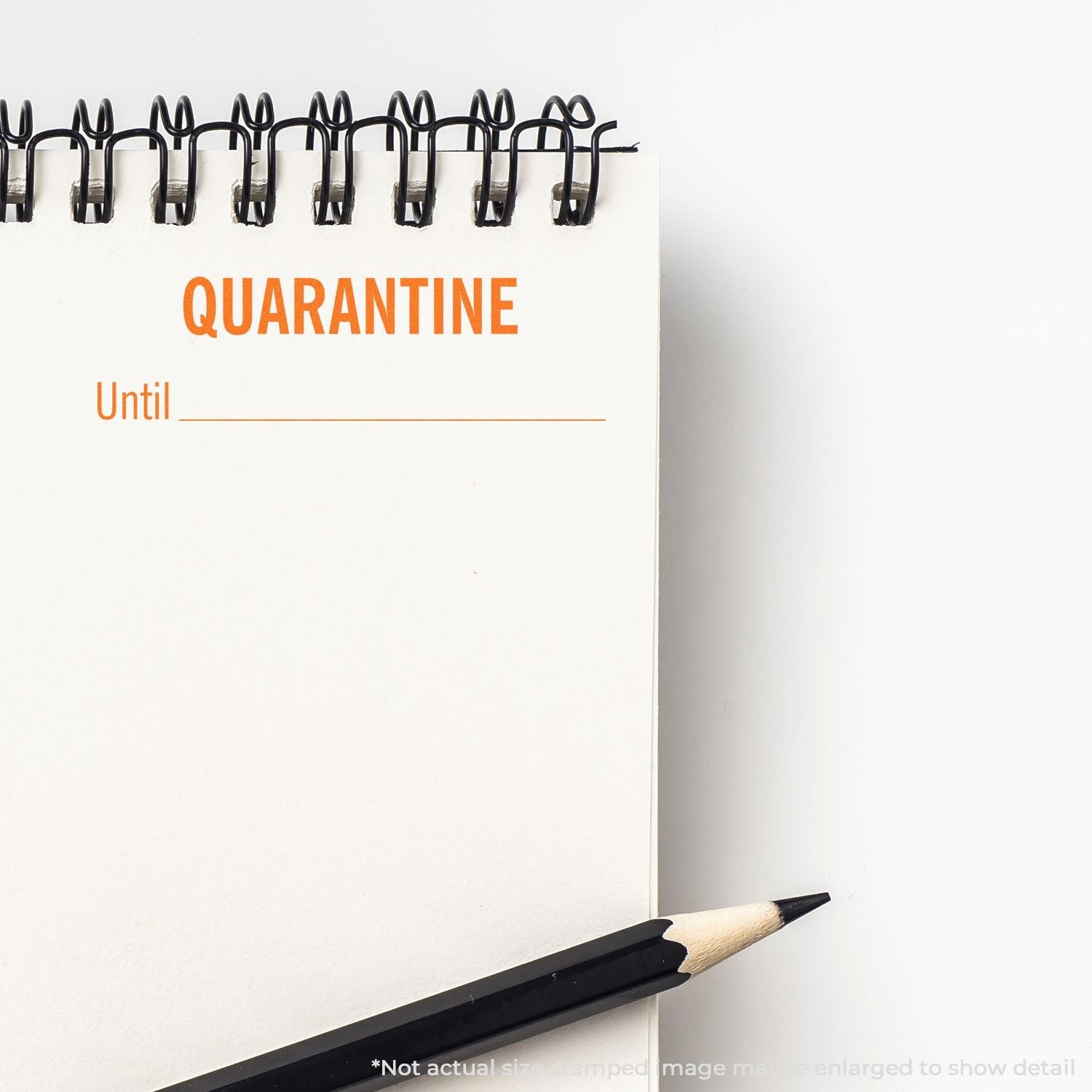 Self Inking Quarantine Until Stamp on a spiral notebook with a pencil beside it, showing QUARANTINE Until _____ text.