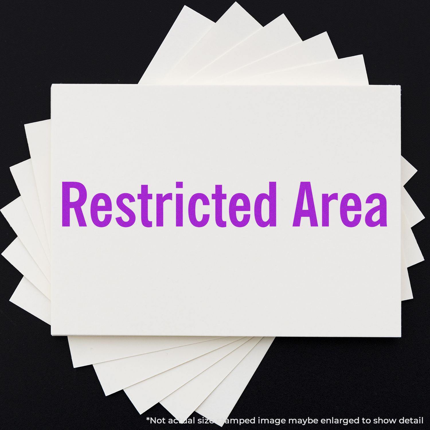 Large Pre-Inked Restricted Area Stamp in use, displaying Restricted Area in purple text on a white card against a black background.