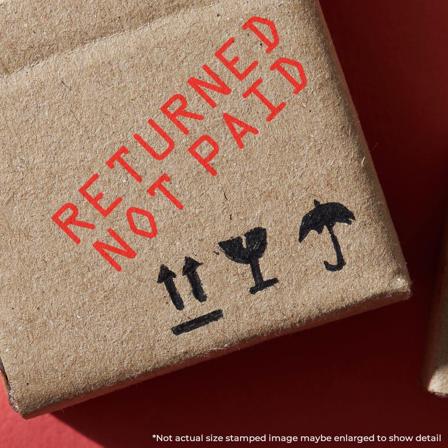 A stock office rubber stamp with a stamped image showing how the text "RETURNED NOT PAID" is displayed after stamping.