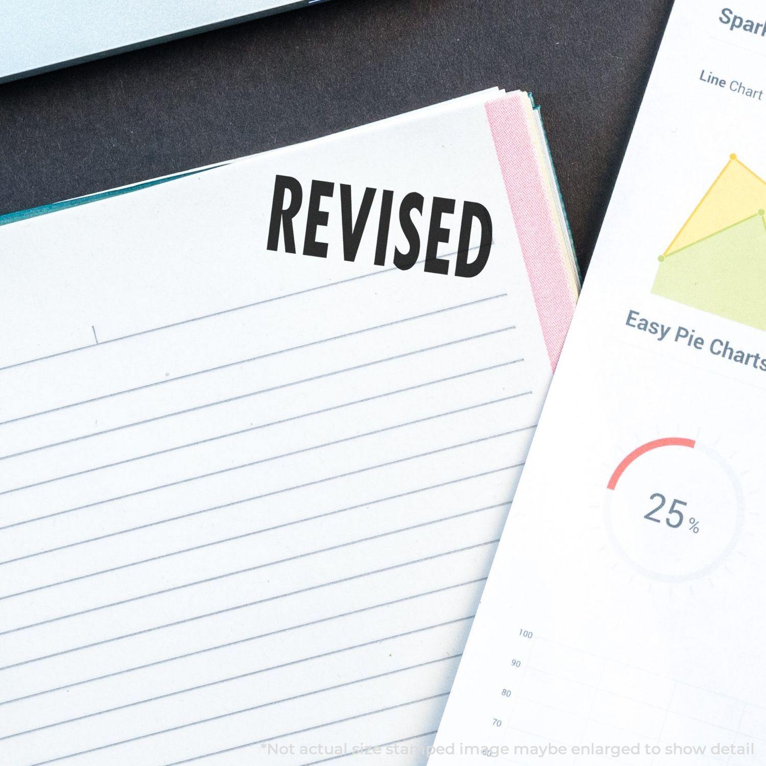 Large Pre-Inked Bold Revised Stamp marking REVISED on a document, next to a chart with a 25% pie chart and a line graph.