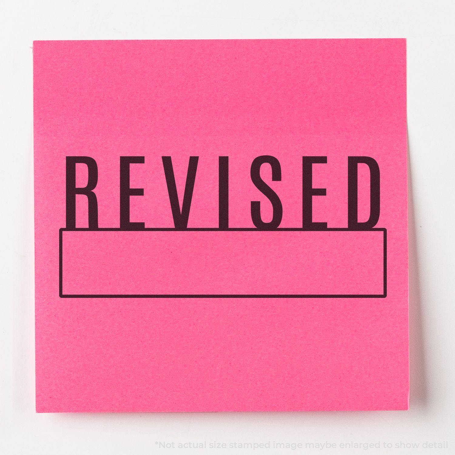 A stock office rubber stamp with a stamped image showing how the text "REVISED" in a large font with a box under the text is displayed after stamping.