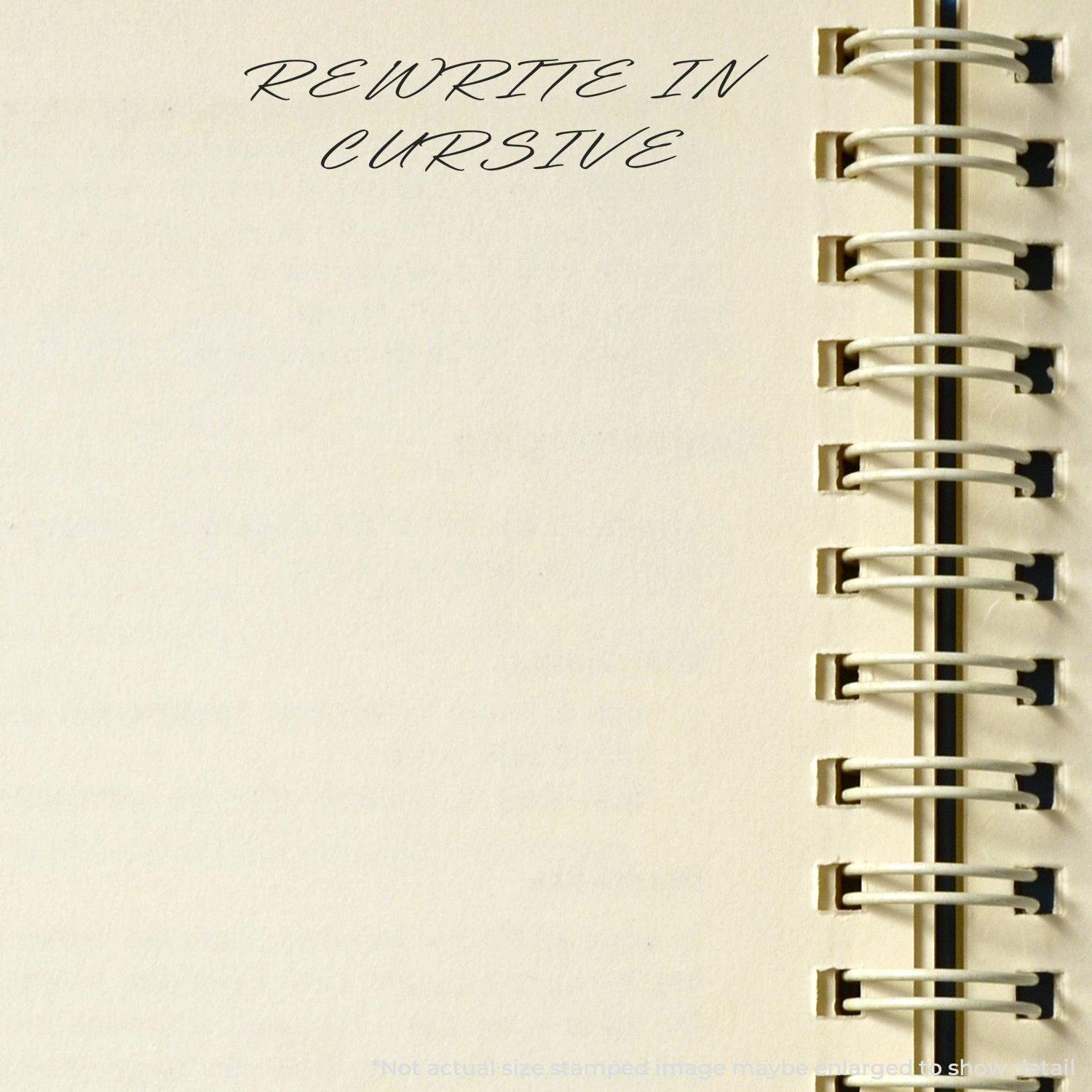 Large Pre-Inked Rewrite In Cursive Stamp used on a blank notebook page with spiral binding, displaying the text REWRITE IN CURSIVE .