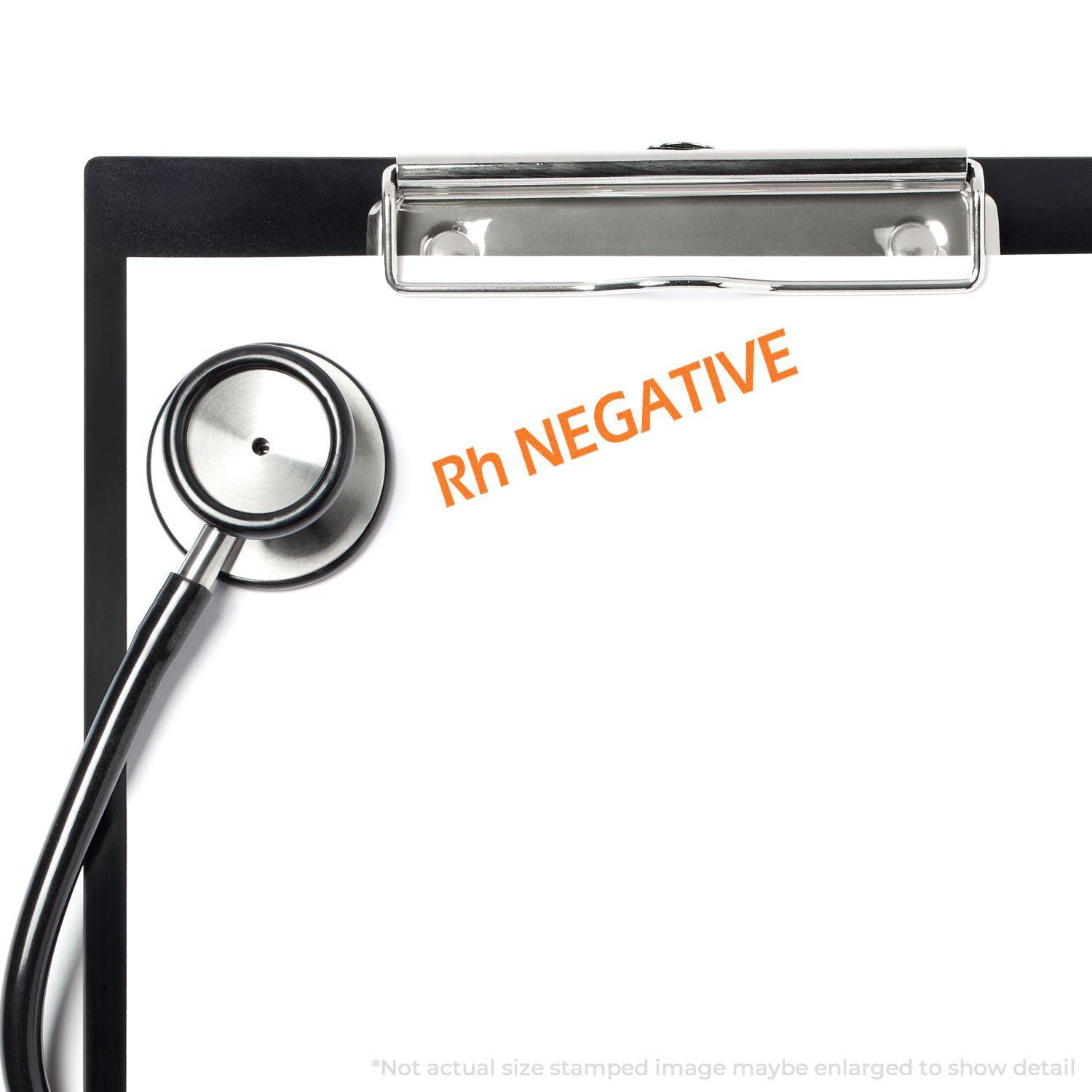 A stethoscope and clipboard with a stamped Rh NEGATIVE in orange ink using the Large Pre-Inked Rh Negative Stamp.