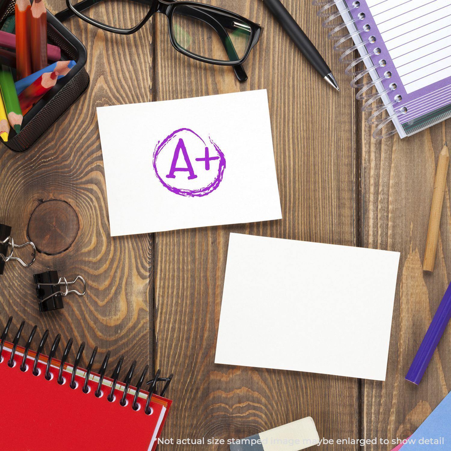 A desk with stationery items and a card stamped with a purple Round A+ Rubber Stamp.