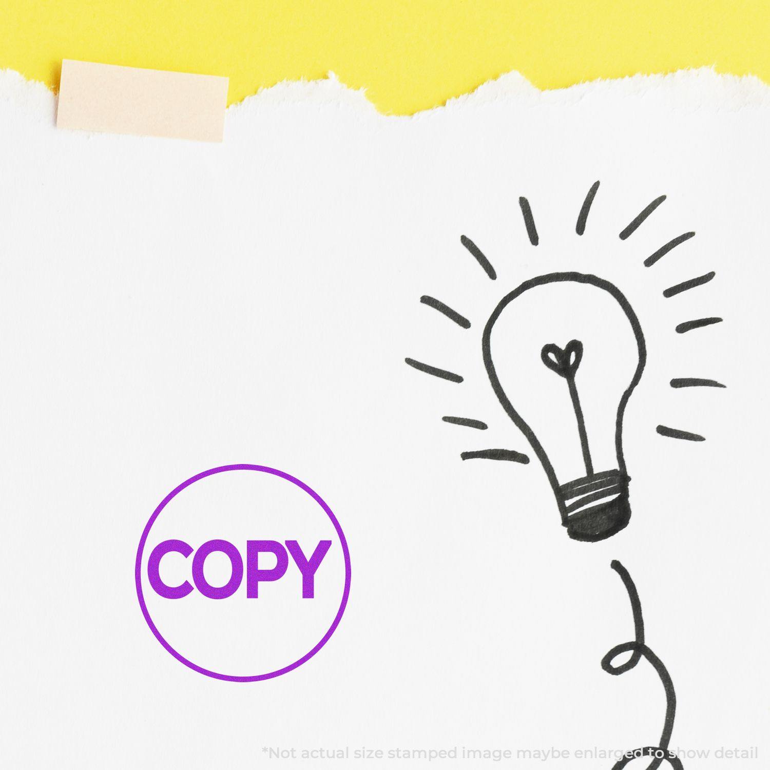 Round Copy Rubber Stamp in purple ink on white paper with a lightbulb drawing, yellow background.