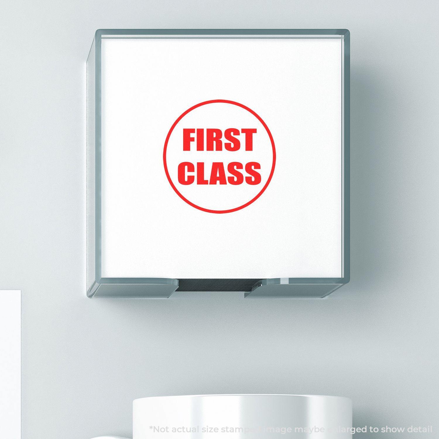 Round First Class rubber stamp with red text on a white background, displayed in a clear holder on a light surface.