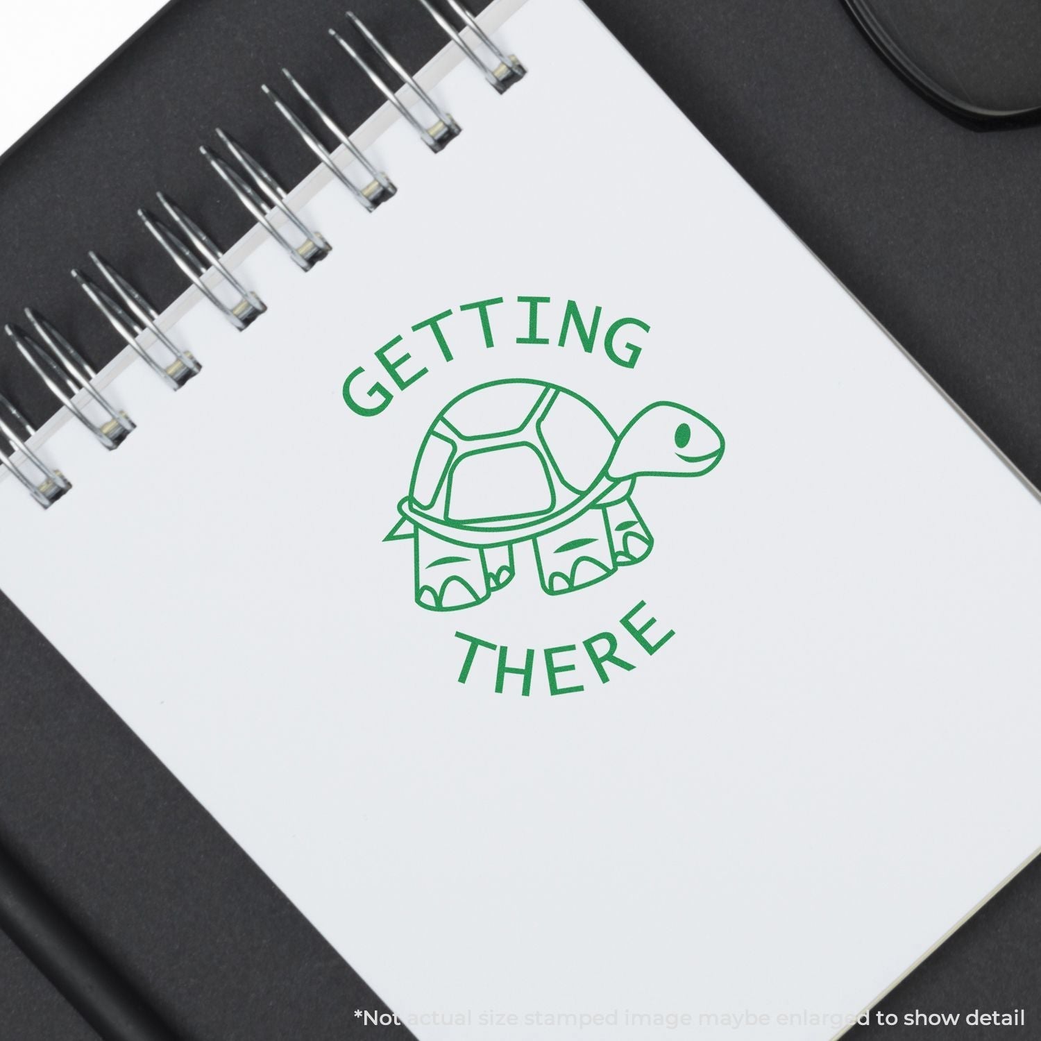 Self Inking Round Getting There Stamp with a green turtle design stamped on a white notebook page.