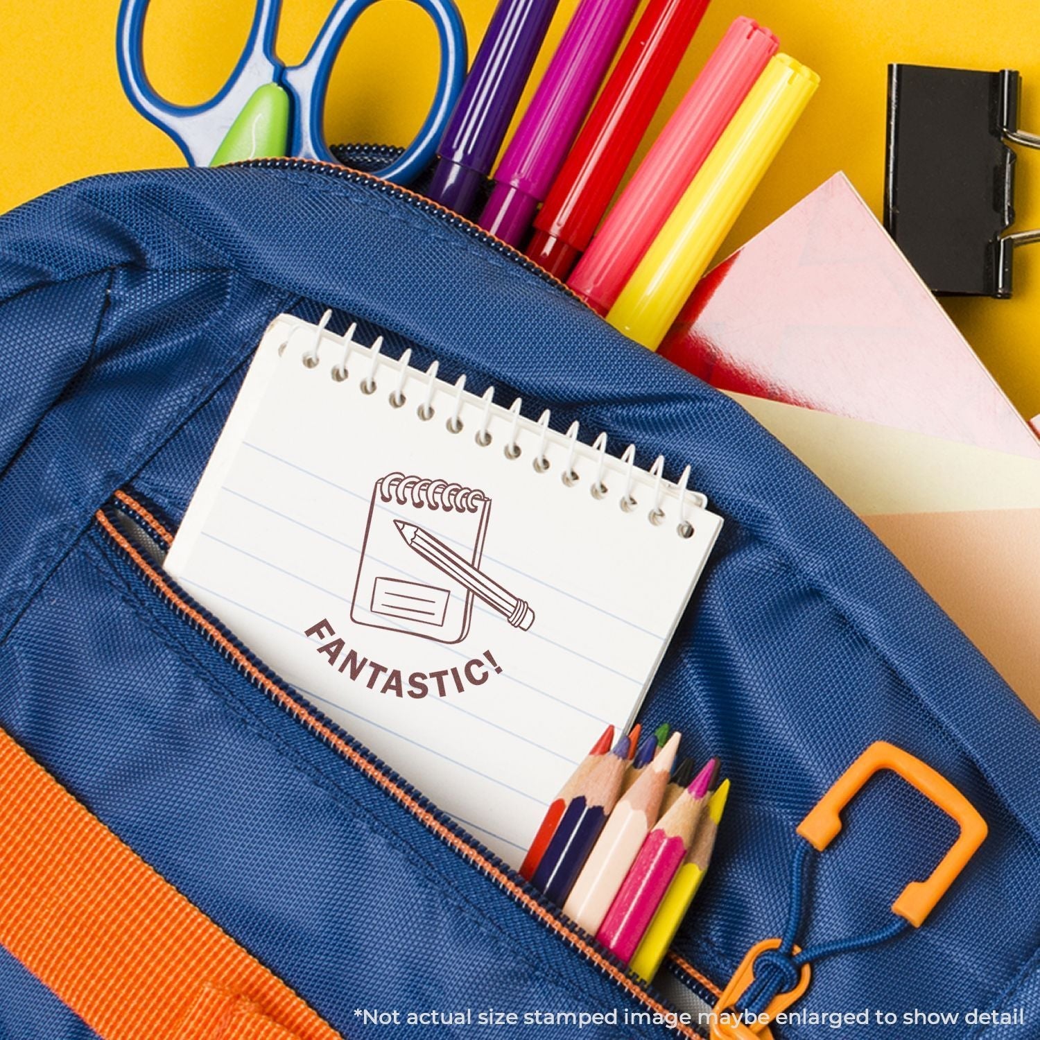 A blue backpack with colored pencils, markers, and a notebook stamped with Fantastic! using the Self Inking Round Great Job Stamp.