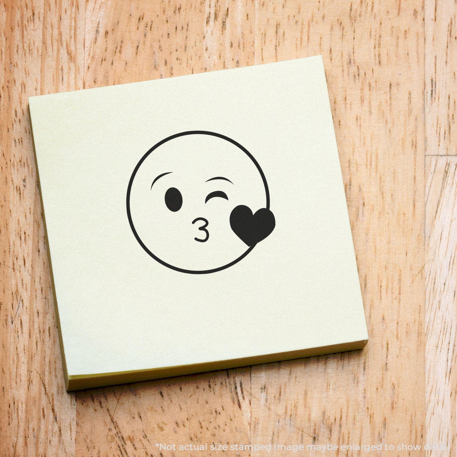 Round Happy Smiley Rubber Stamp on a light-colored sticky note, featuring a winking face blowing a kiss with a heart.