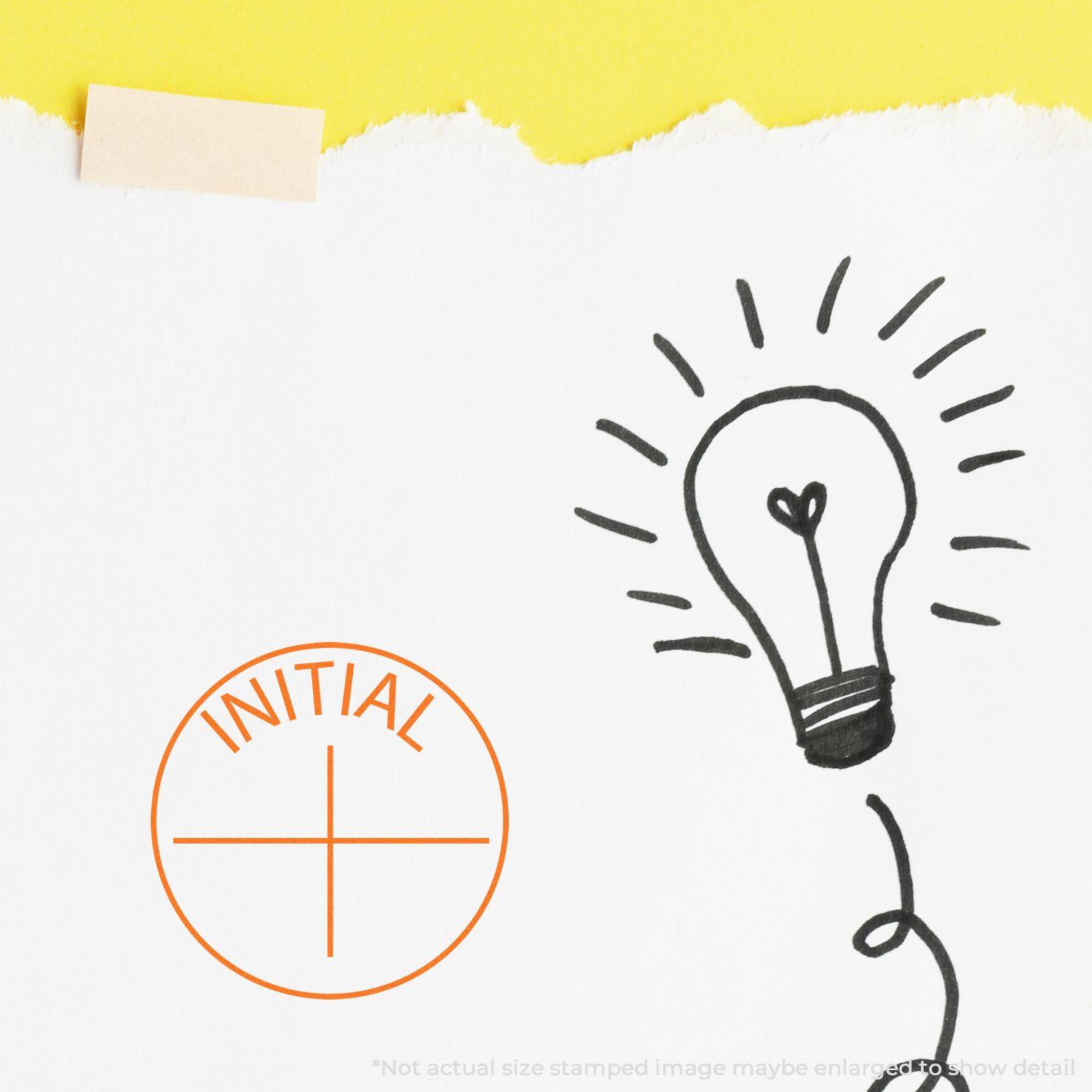 Round Initial Rubber Stamp in orange ink next to a hand-drawn light bulb on white paper with a yellow background.