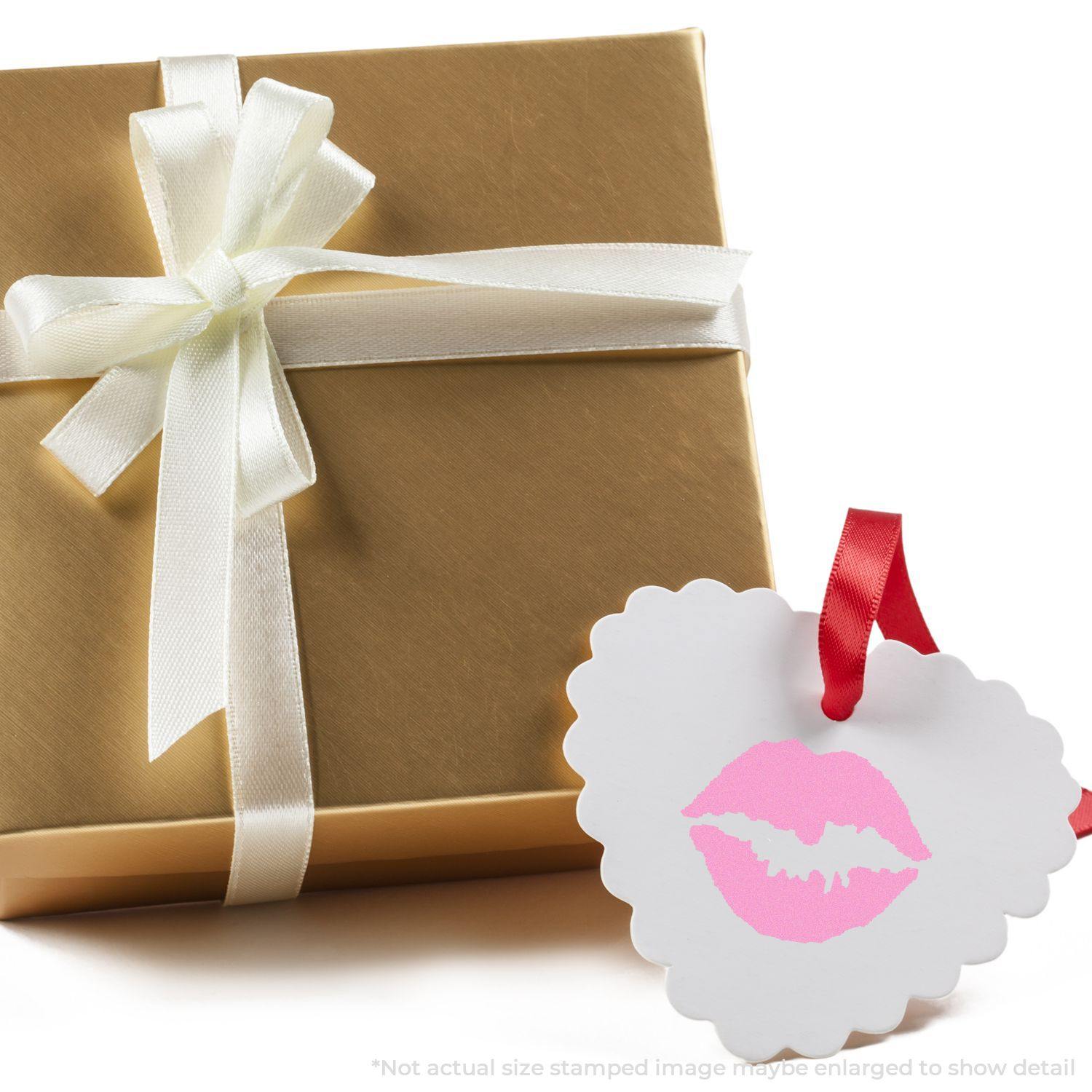 Gift box with white ribbon and a heart-shaped tag featuring a pink Round Kiss Rubber Stamp design hanging from a red ribbon.