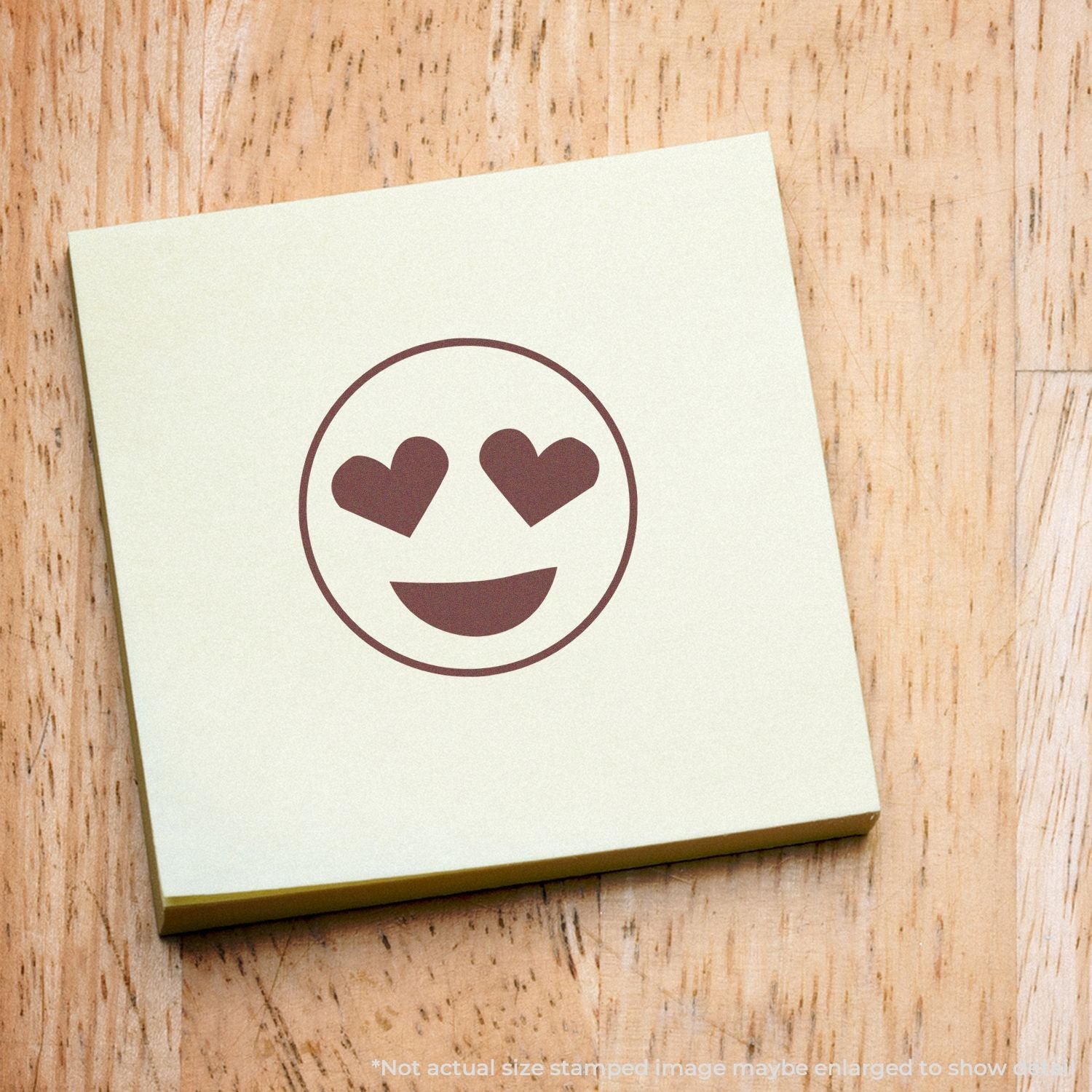 Self Inking Round Smiley with Hearts Stamp on a yellow sticky note, showing a smiley face with heart eyes and a wide smile.