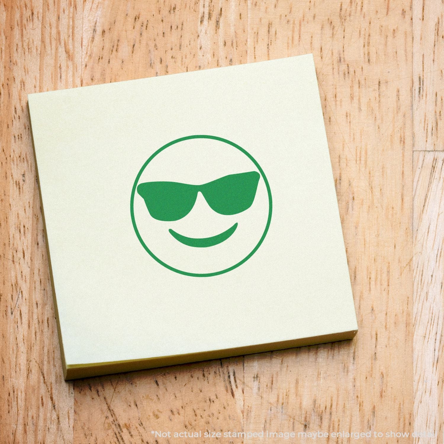 Self Inking Round Smiley with Sunglasses Stamp on a yellow sticky note, featuring a green smiley face wearing sunglasses.