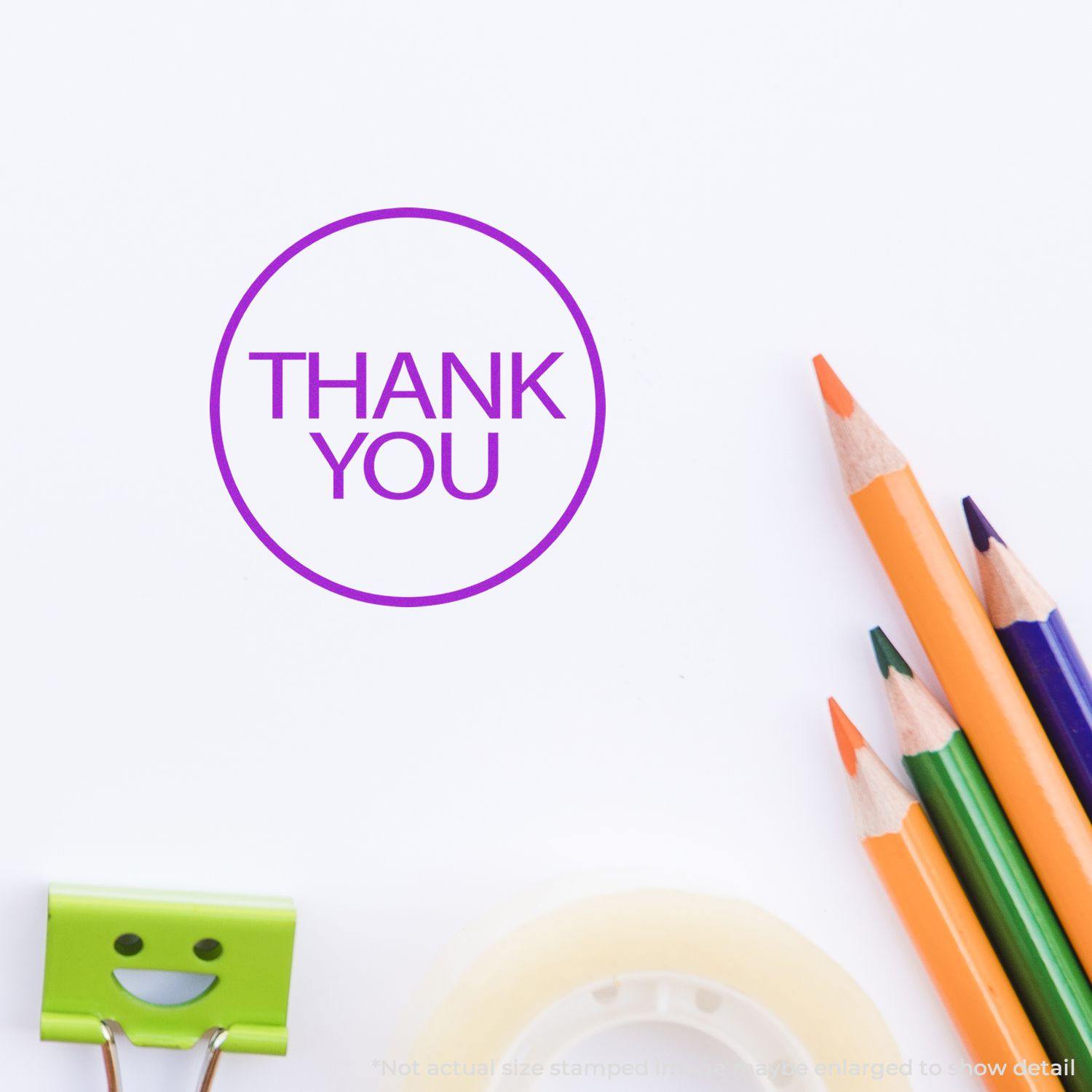 Round Thank You Rubber Stamp in purple ink on white paper, surrounded by colorful pencils, a green clip, and tape.