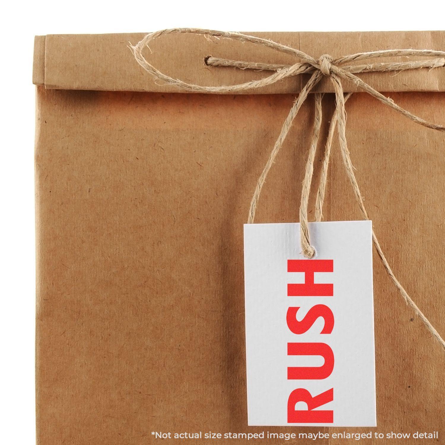 A brown paper package with a tag stamped RUSH using the Large Pre-Inked Rush Stamp, tied with twine.