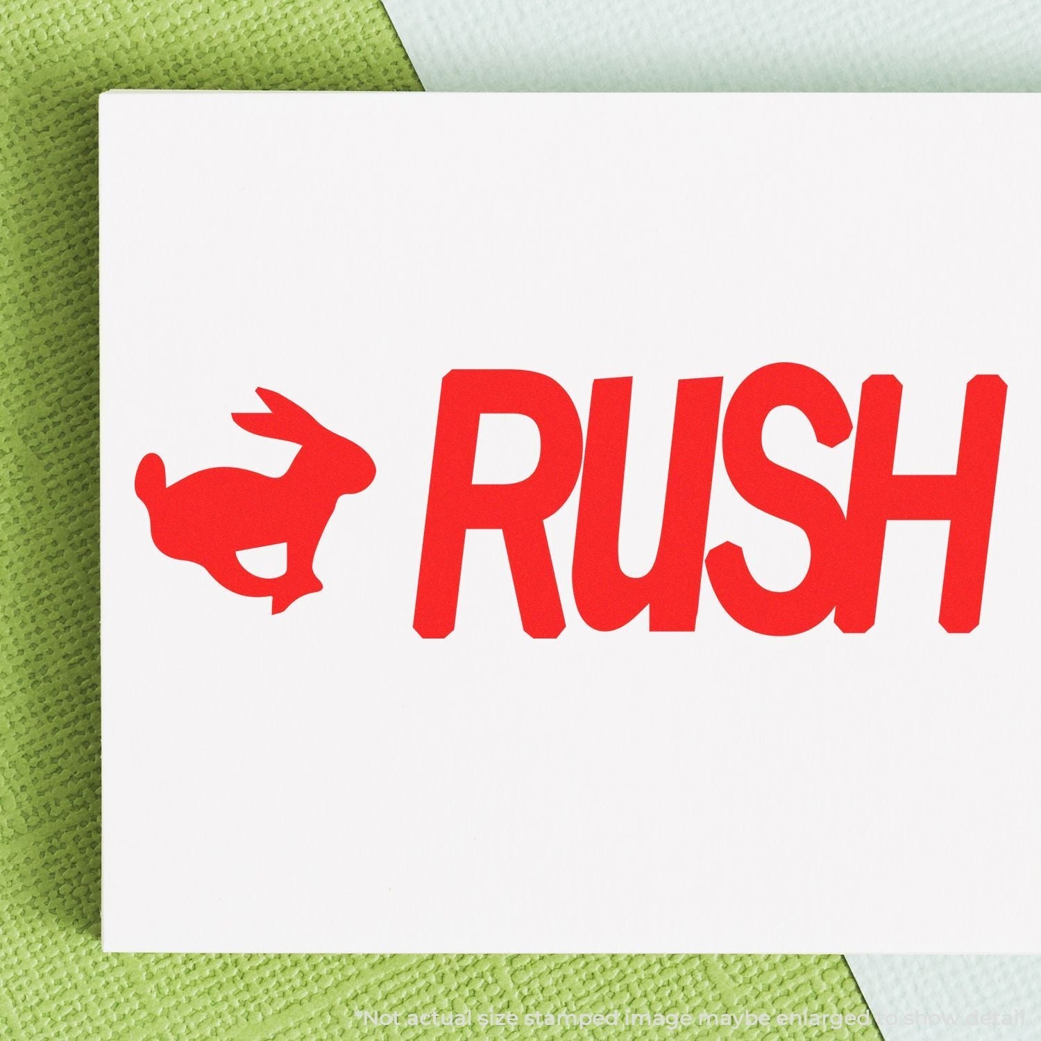 A self-inking stamp with a stamped image showing how the text "RUSH" in bold font and an image of a rabbit on the left is displayed after stamping.