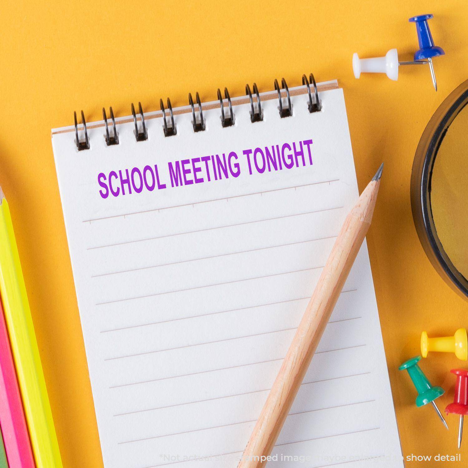 Notepad stamped with SCHOOL MEETING TONIGHT using the Large School Meeting Tonight Rubber Stamp, surrounded by colorful office supplies.