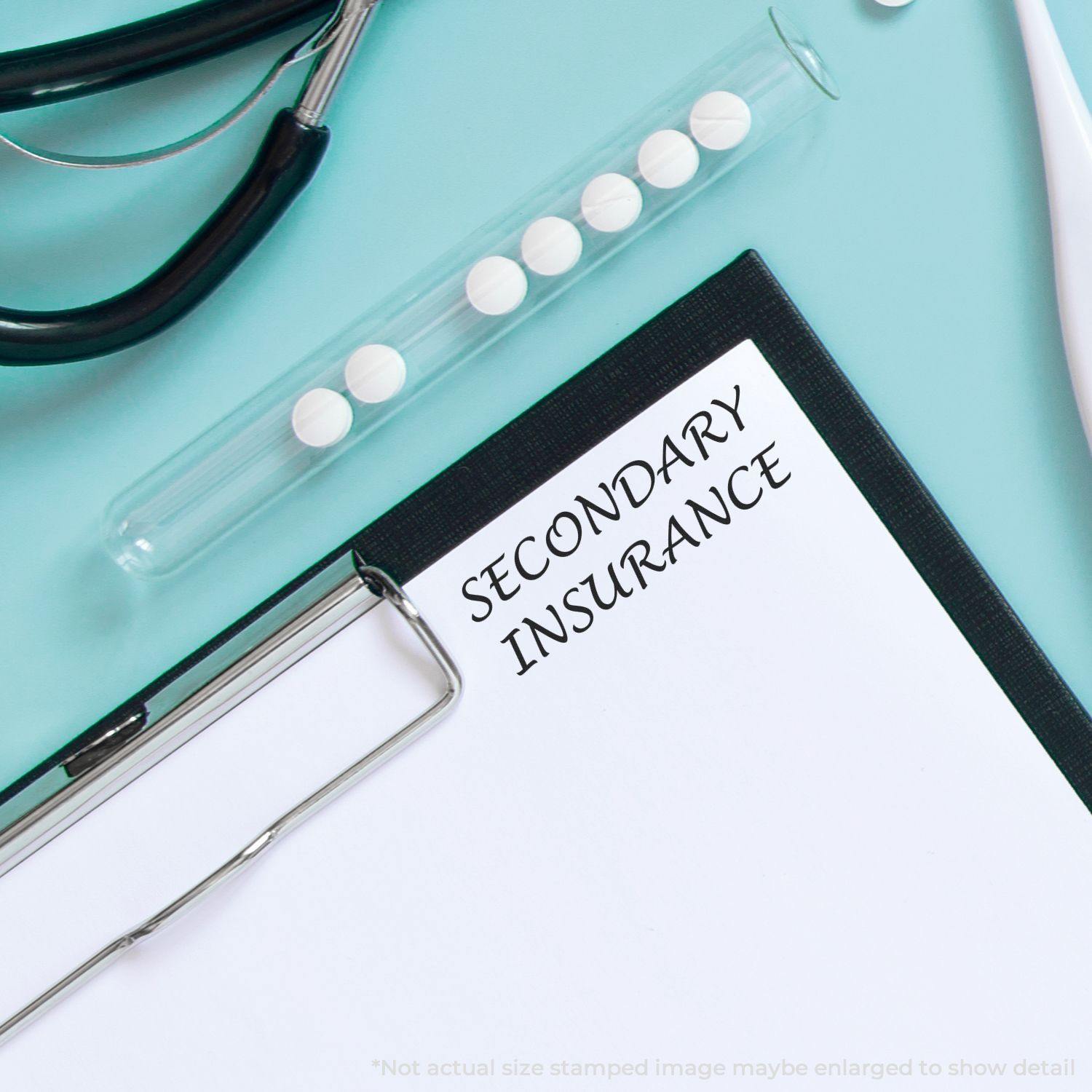 Clipboard with SECONDARY INSURANCE stamped using the Large Pre-Inked Secondary Insurance Stamp, surrounded by medical tools and pills.