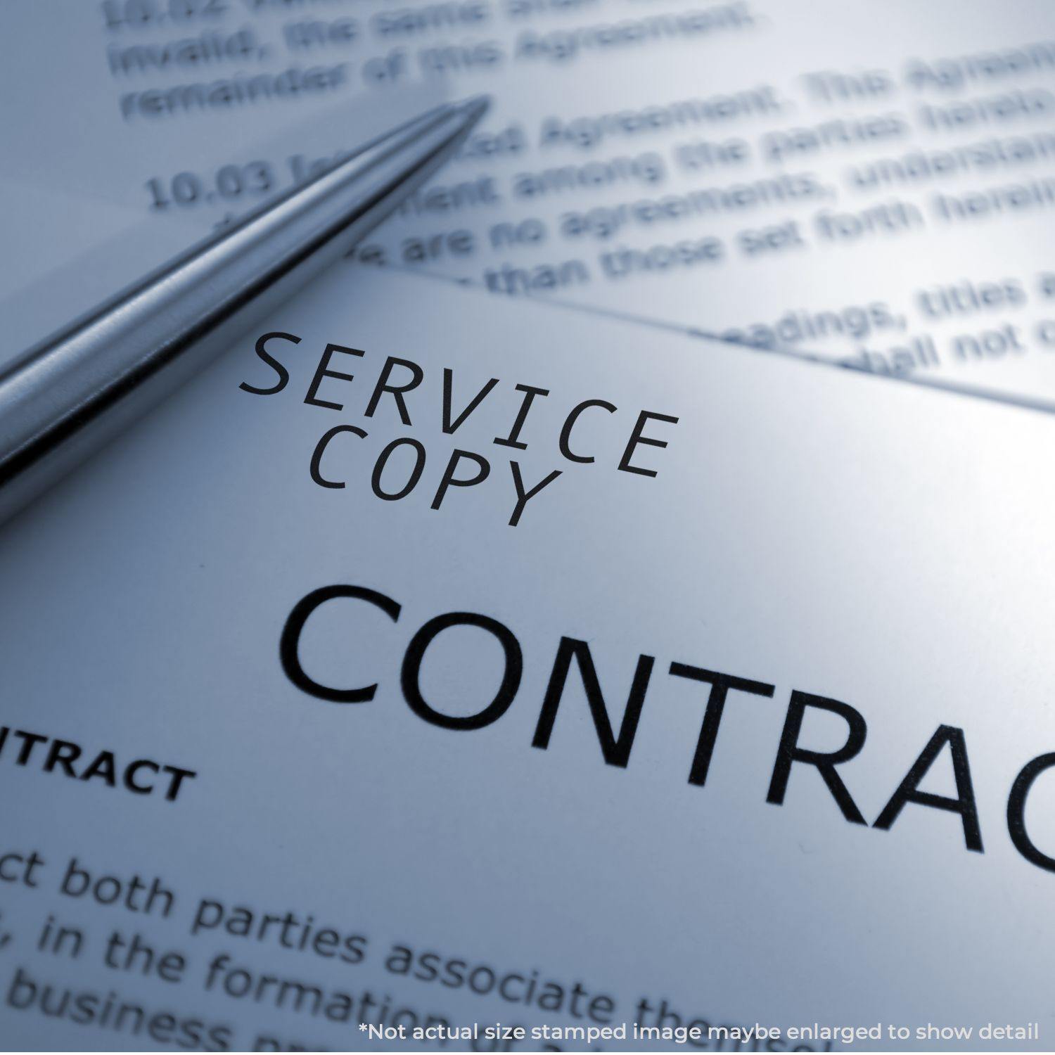 Large Service Copy Rubber Stamp on a contract document, with a pen nearby and text in the background.