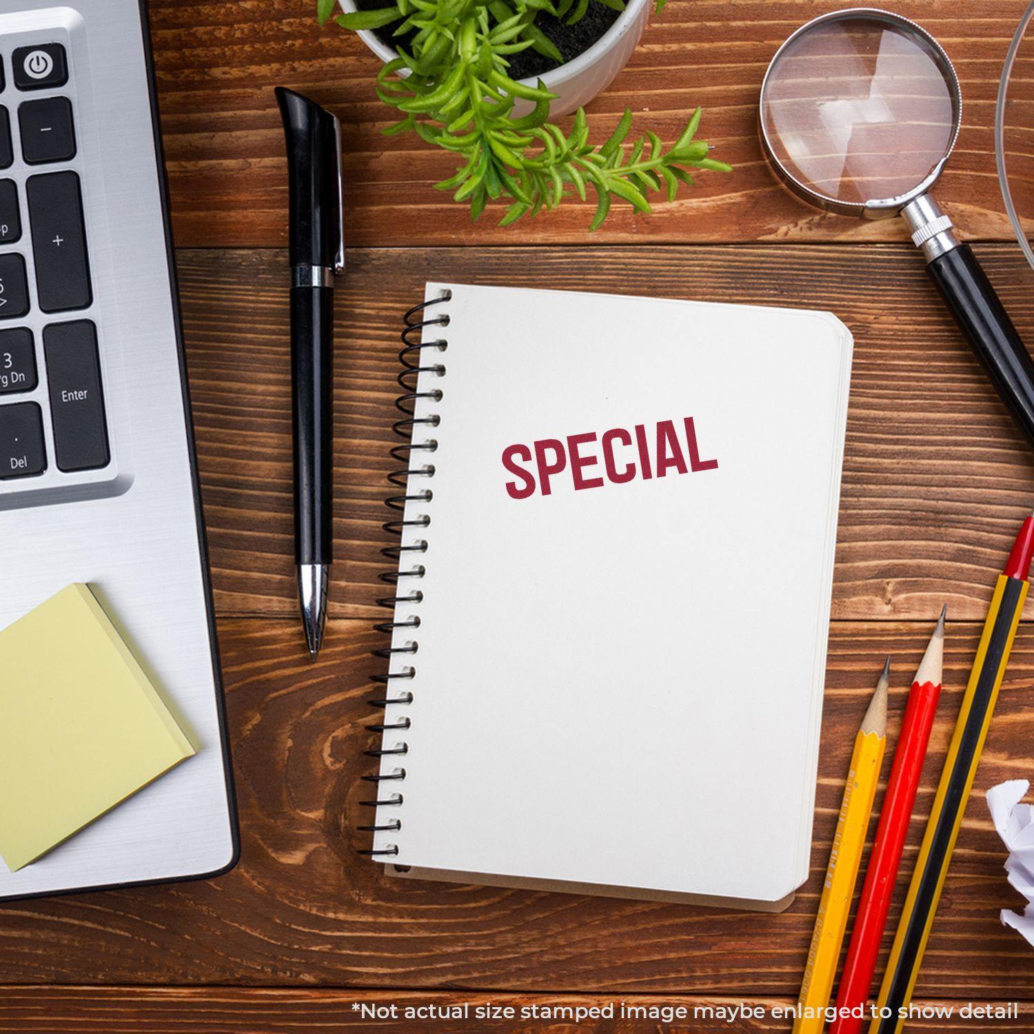 Notebook with SPECIAL stamped in red using a special rubber stamp, surrounded by office supplies on a wooden desk.