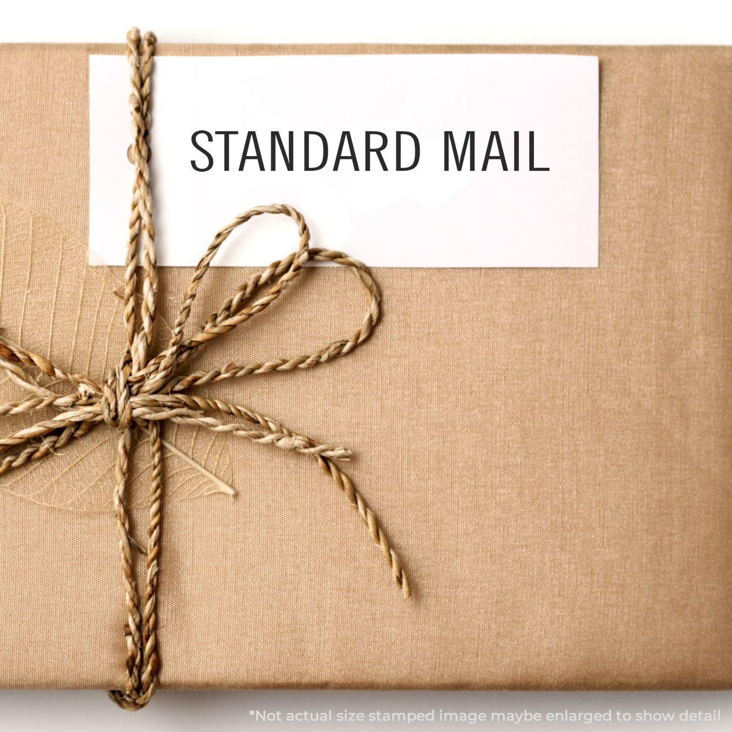 A self-inking stamp with a stamped image showing how the text "STANDARD MAIL" is displayed after stamping.