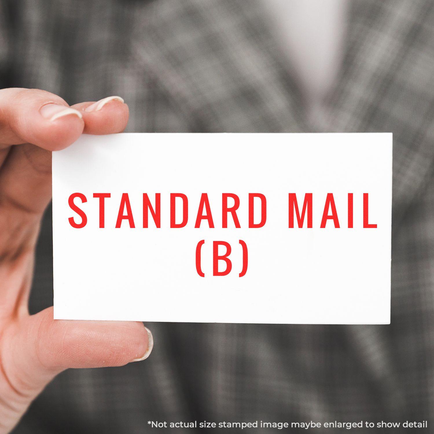 Person holding a card stamped with STANDARD MAIL (B) in red ink using the Large Pre-Inked Standard Mail (B) Stamp.