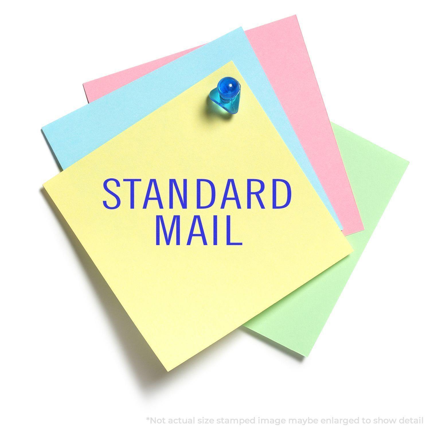 Large Standard Mail Stacked Rubber Stamp impression on colorful sticky notes, with a blue push pin on top.