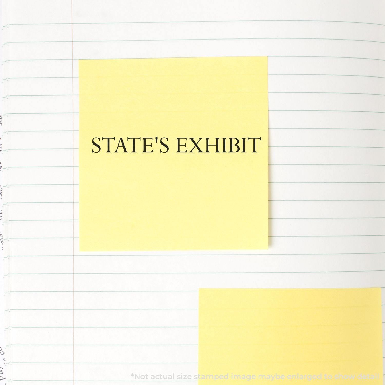 Large States Exhibit Rubber Stamp impression on a yellow sticky note placed on a lined notebook page.