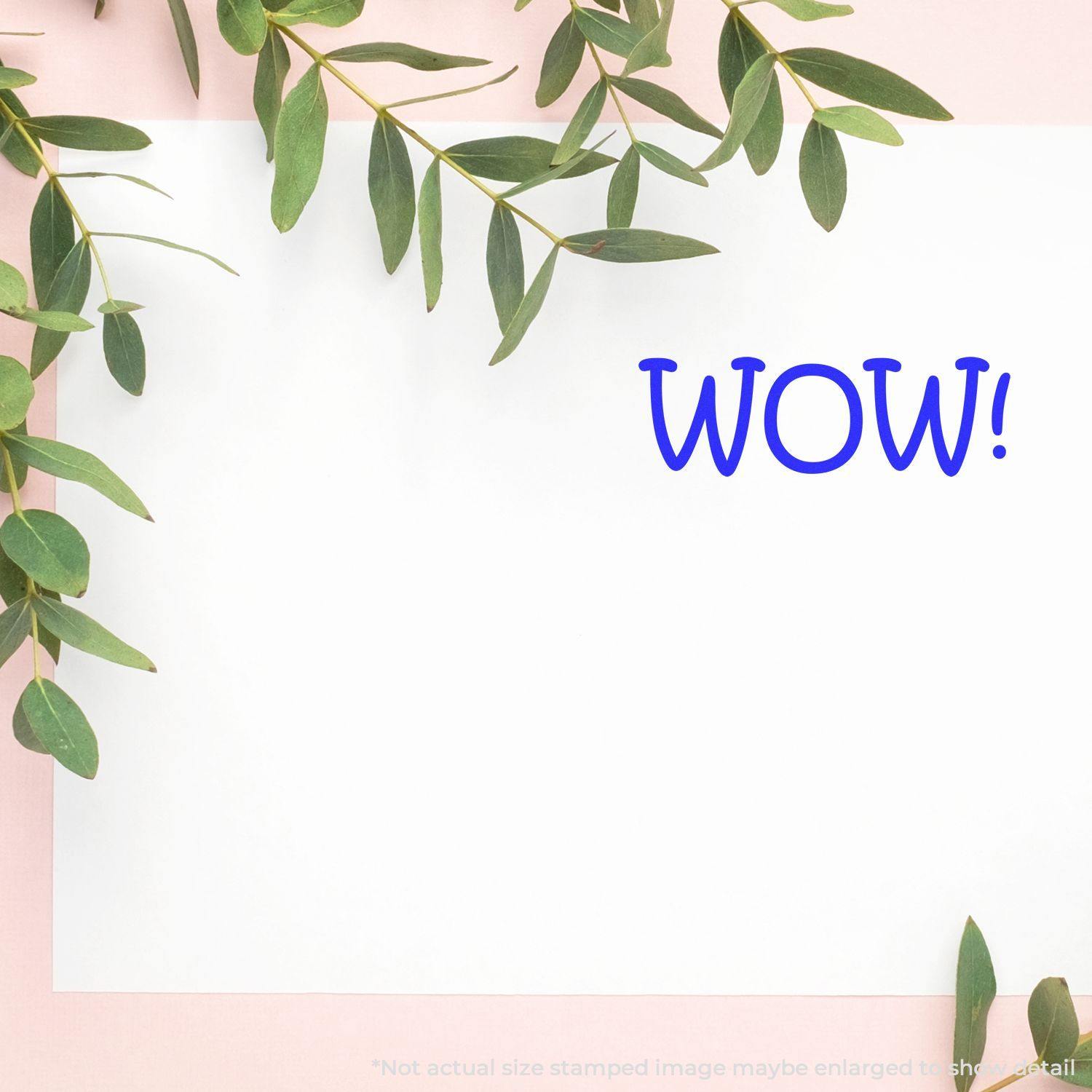 Large Pre-Inked Wow Stamp used on white paper with green leaves on a pink background. The word WOW! is stamped in blue.