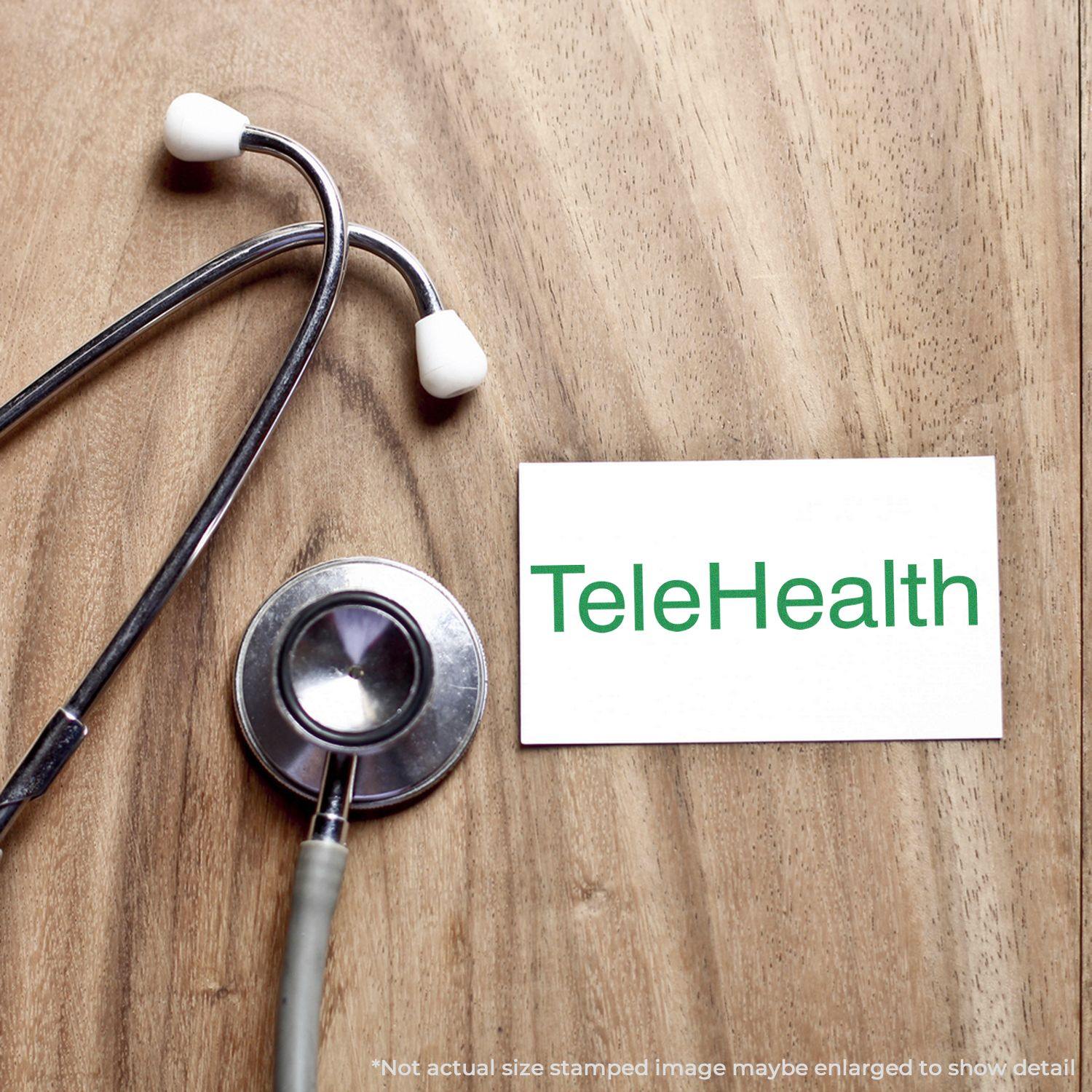 Self Inking Telehealth Stamp on a wooden surface next to a stethoscope and a card with TeleHealth written in green.