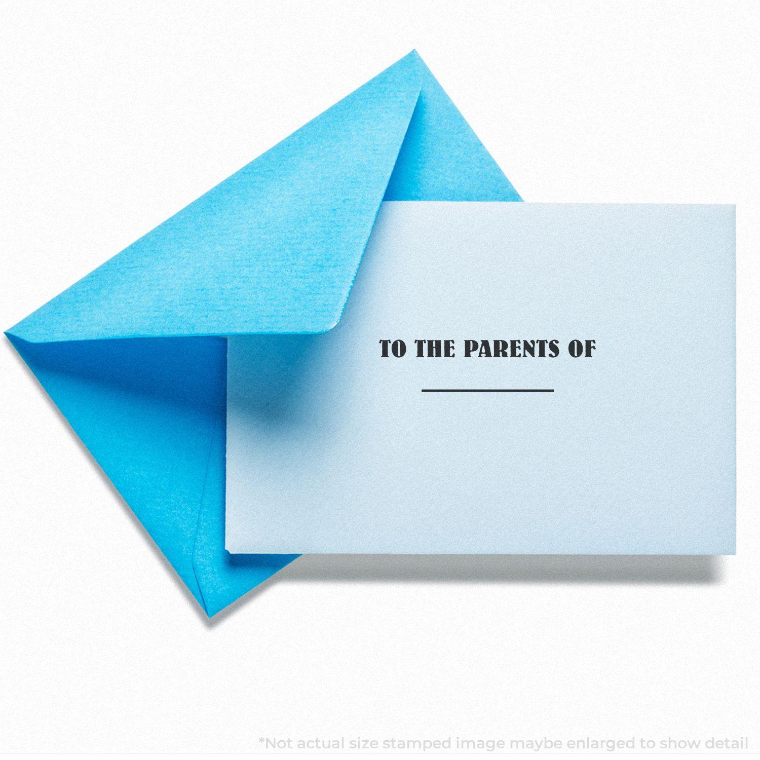 A blue envelope with a card stamped TO THE PARENTS OF using the Self Inking To The Parents Of Stamp, placed on a white background.