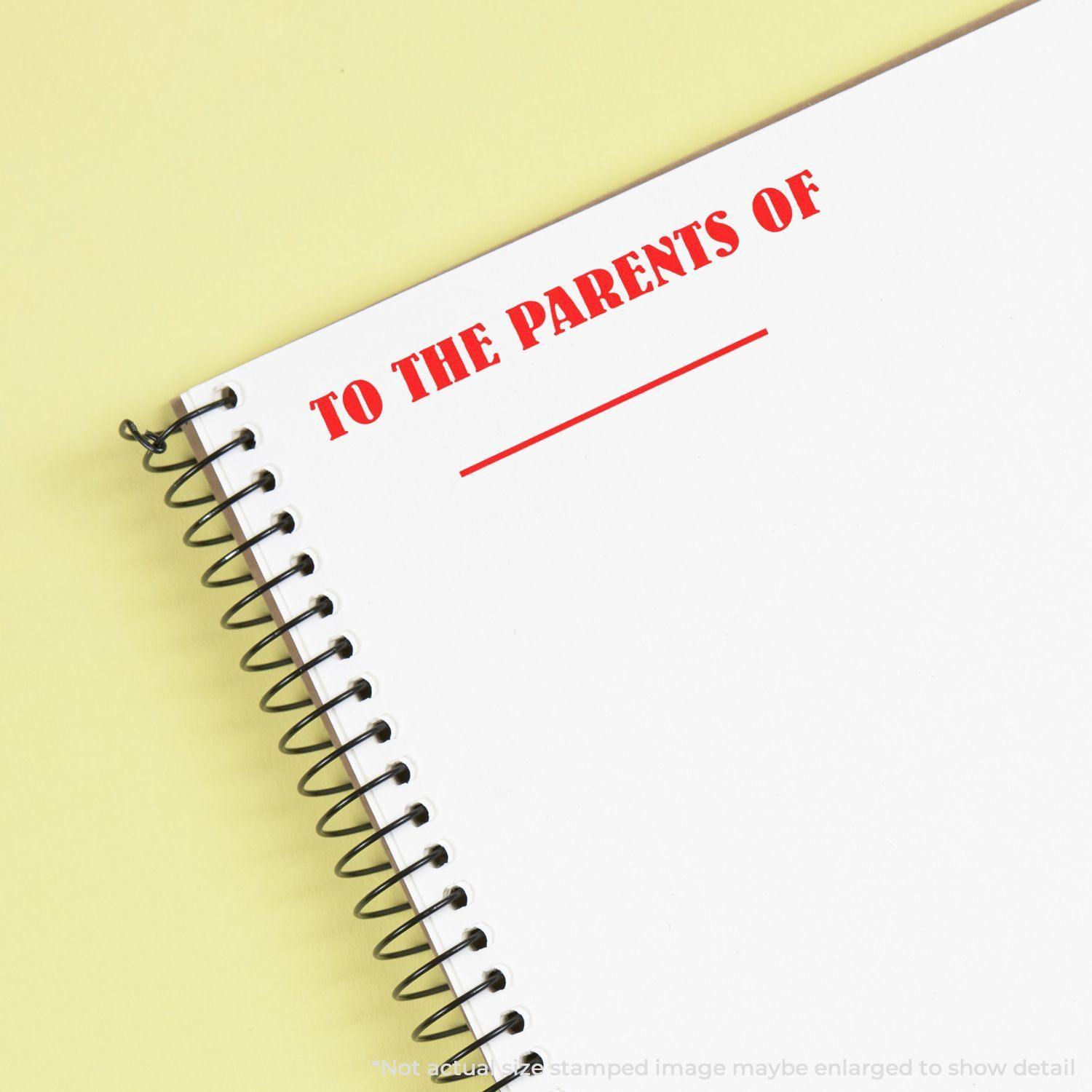 Large Pre-Inked To The Parents Of Stamp used on a spiral notebook, displaying red text TO THE PARENTS OF with a blank line below.