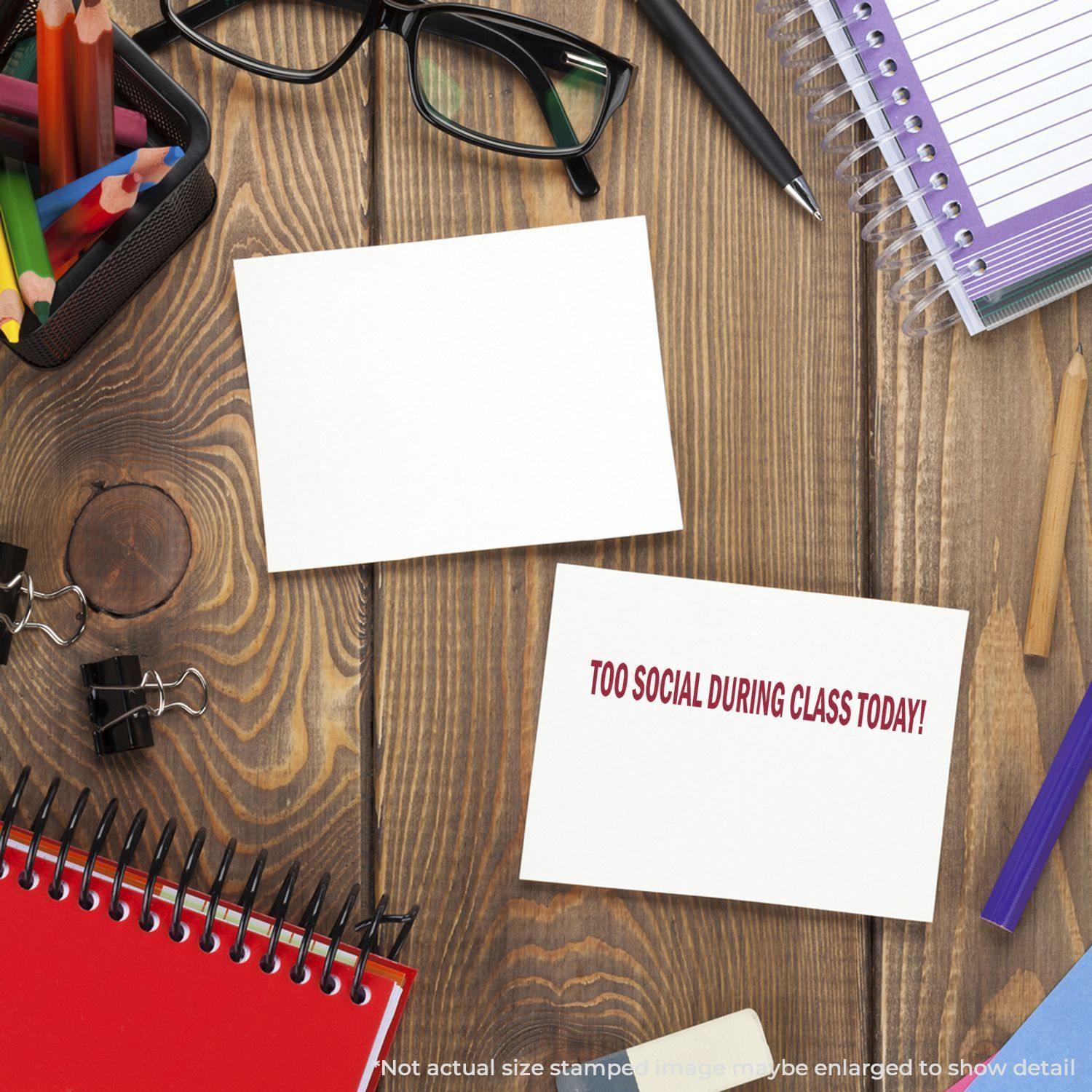 A desk with stationery, glasses, and a card stamped with Too Social During Class Today Rubber Stamp in red ink.