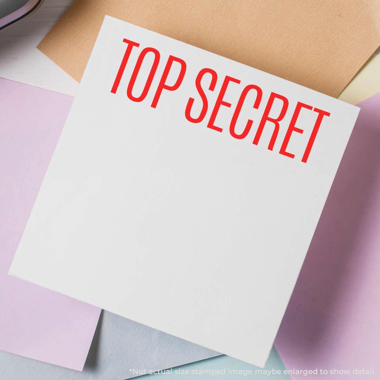 Large Pre-Inked Top Secret Stamp in red ink on a white paper, surrounded by pastel-colored papers.