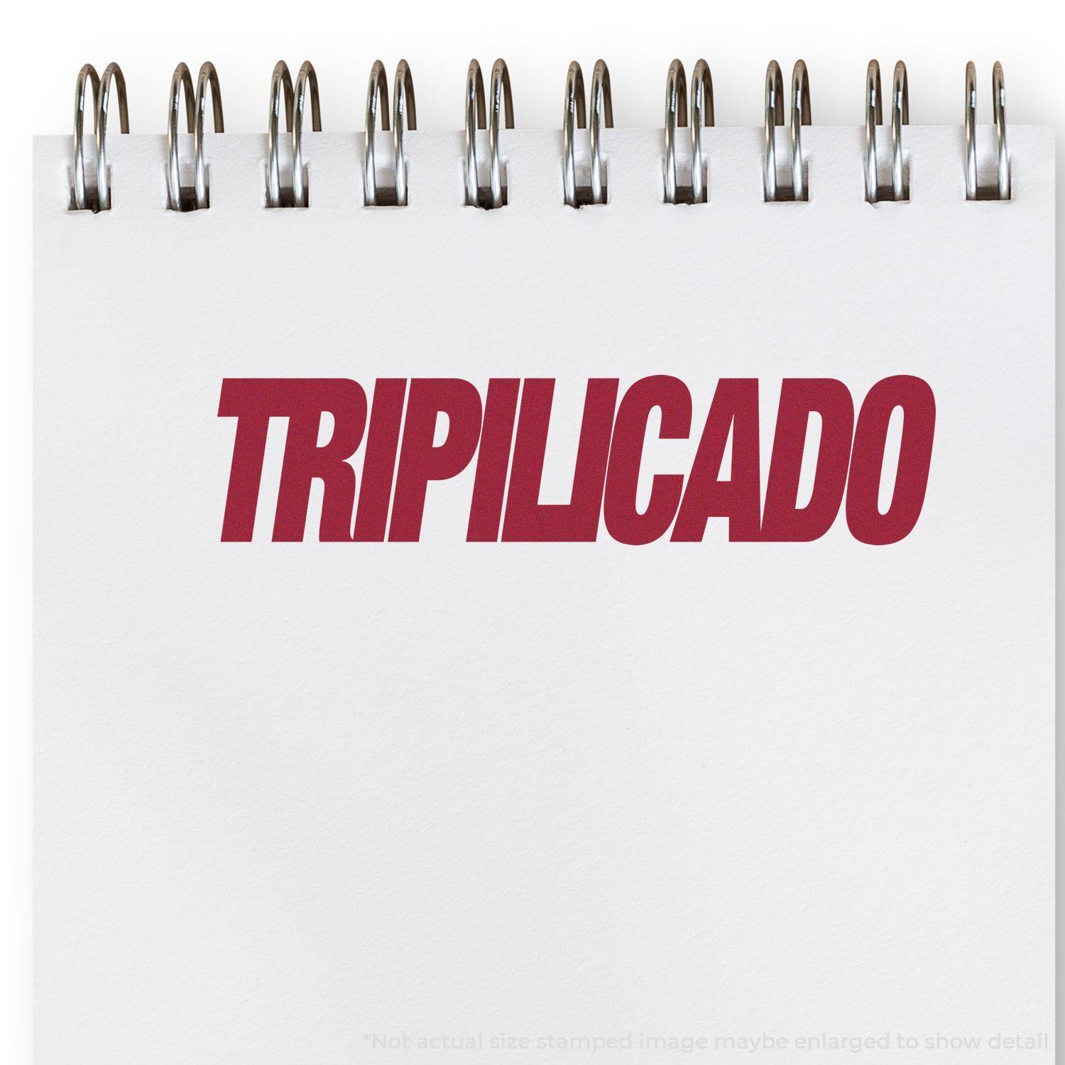 Large Pre-Inked Tripilicado Stamp imprint on a white notepad with spiral binding, showing the word TRIPILICADO in bold red letters.