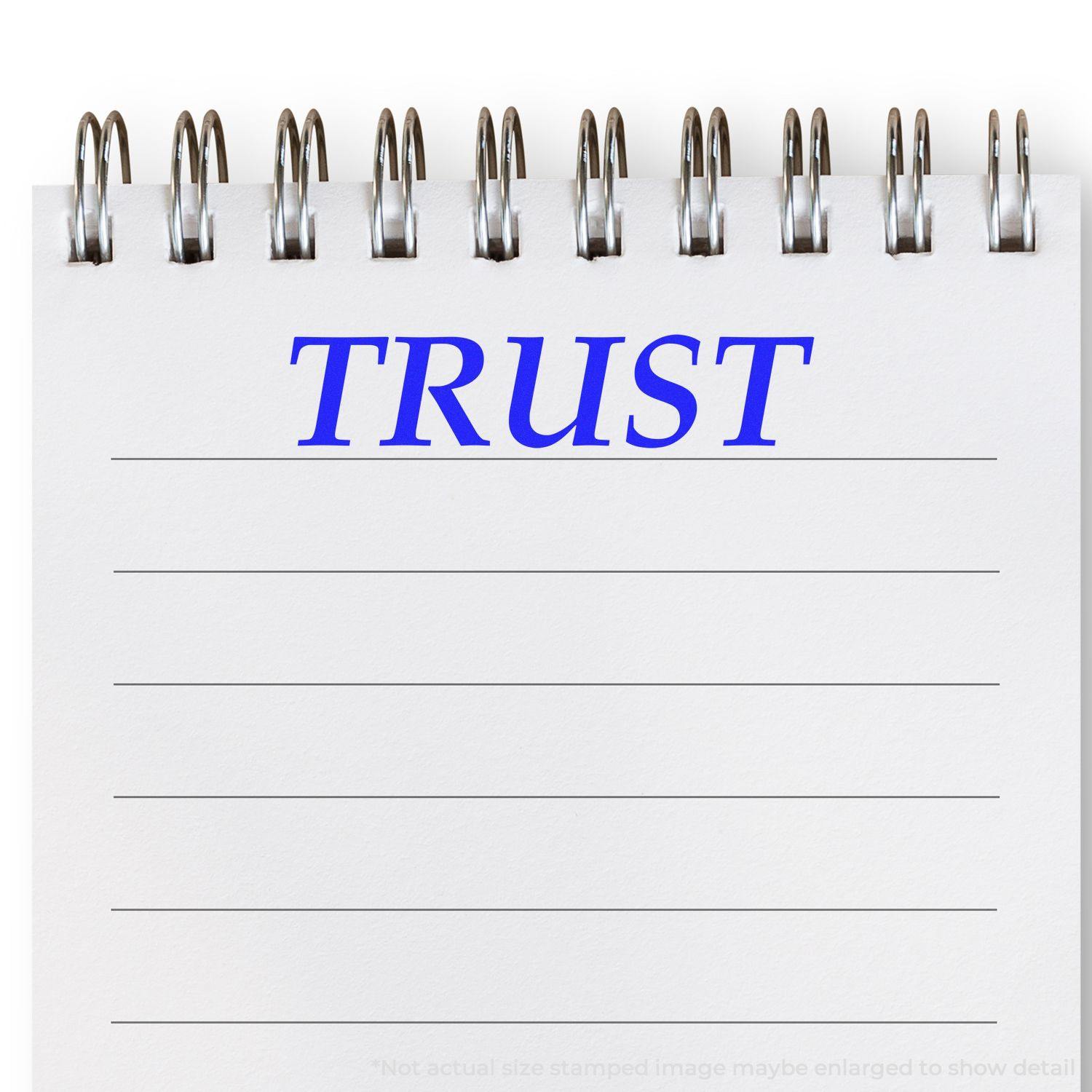 A stock office rubber stamp with a stamped image showing how the text "TRUST" in a large font is displayed after stamping.