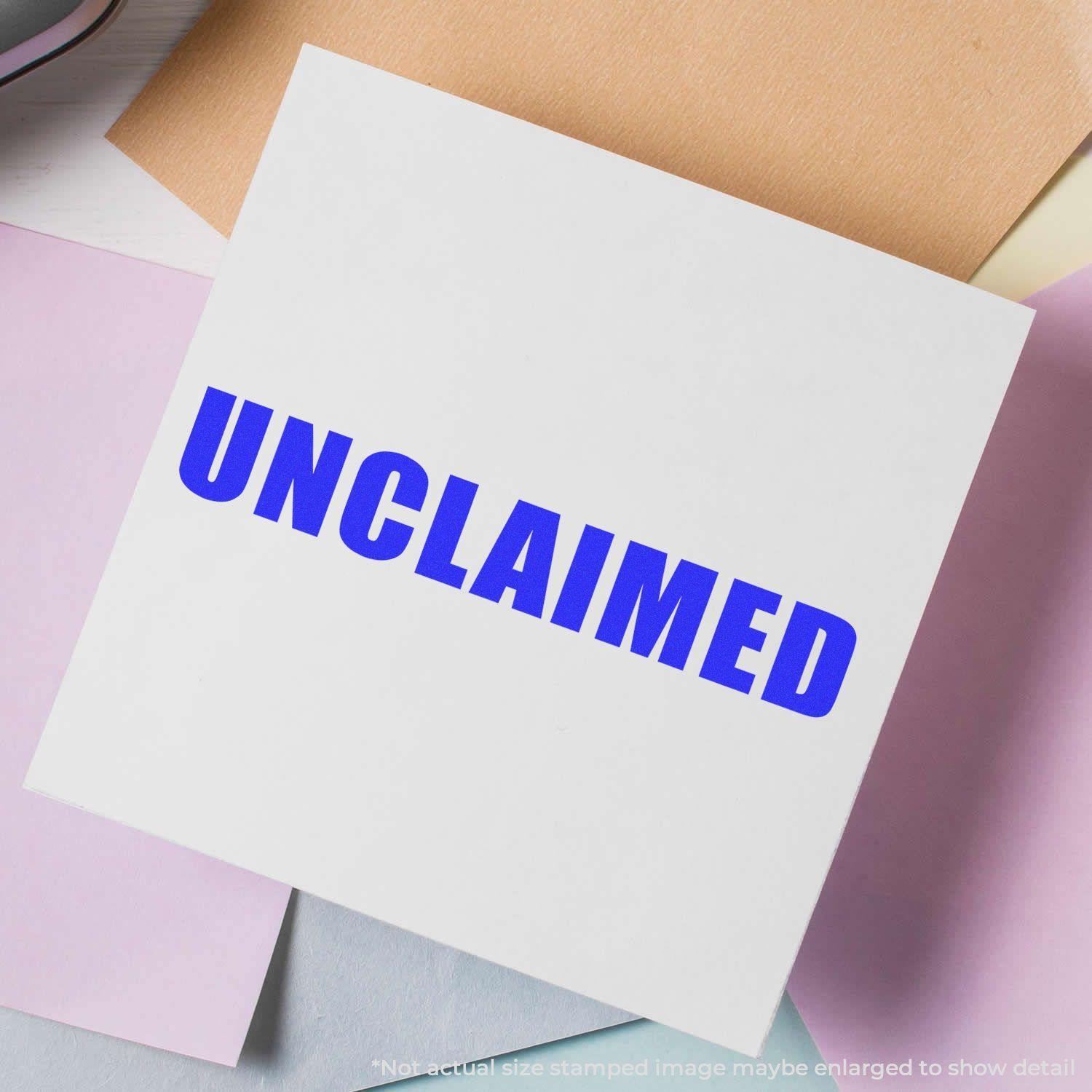 A white paper stamped with a blue 'Unclaimed' rubber stamp, surrounded by pastel-colored papers on a light surface.