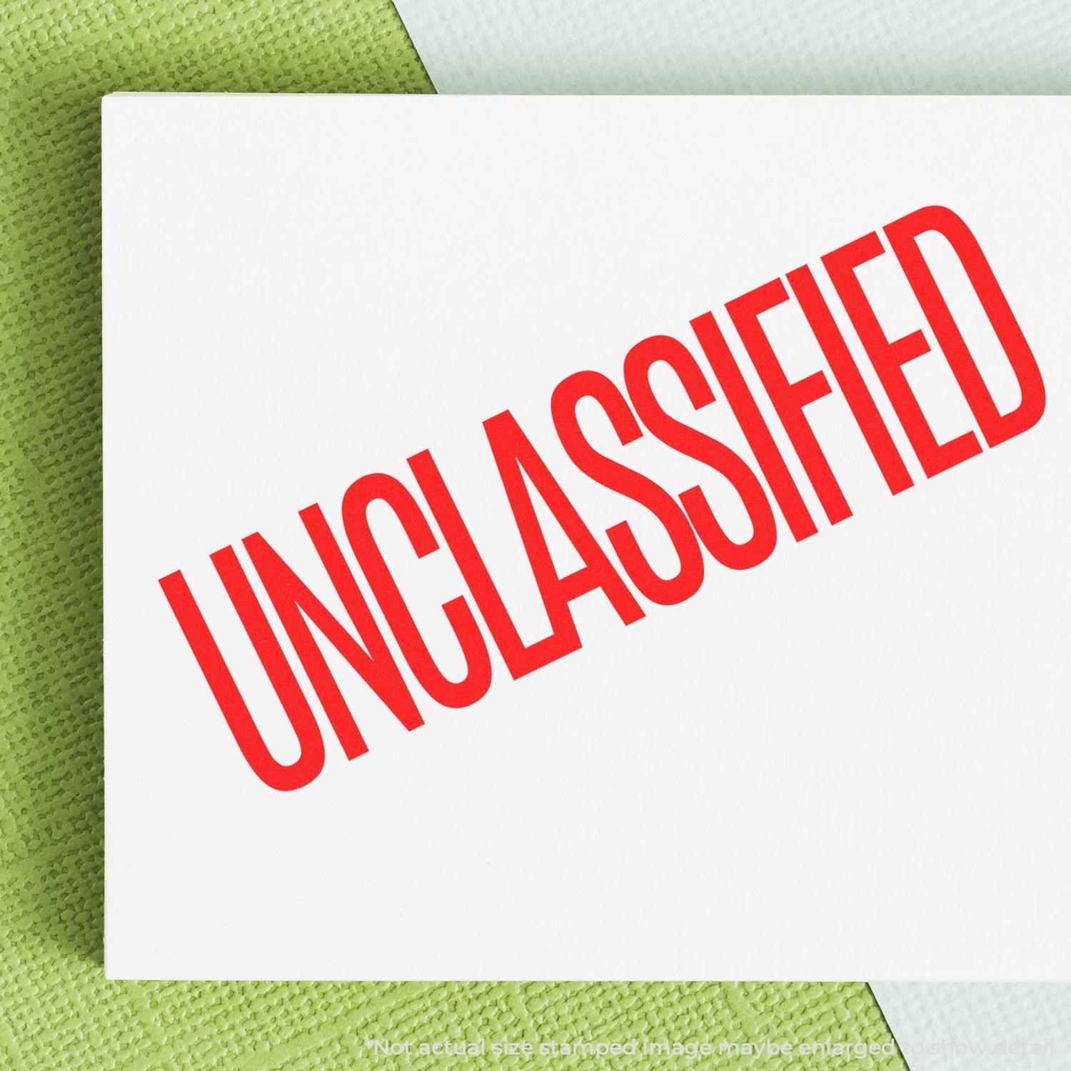 A stock office rubber stamp with a stamped image showing how the text "UNCLASSIFIED" in a large font is displayed after stamping.