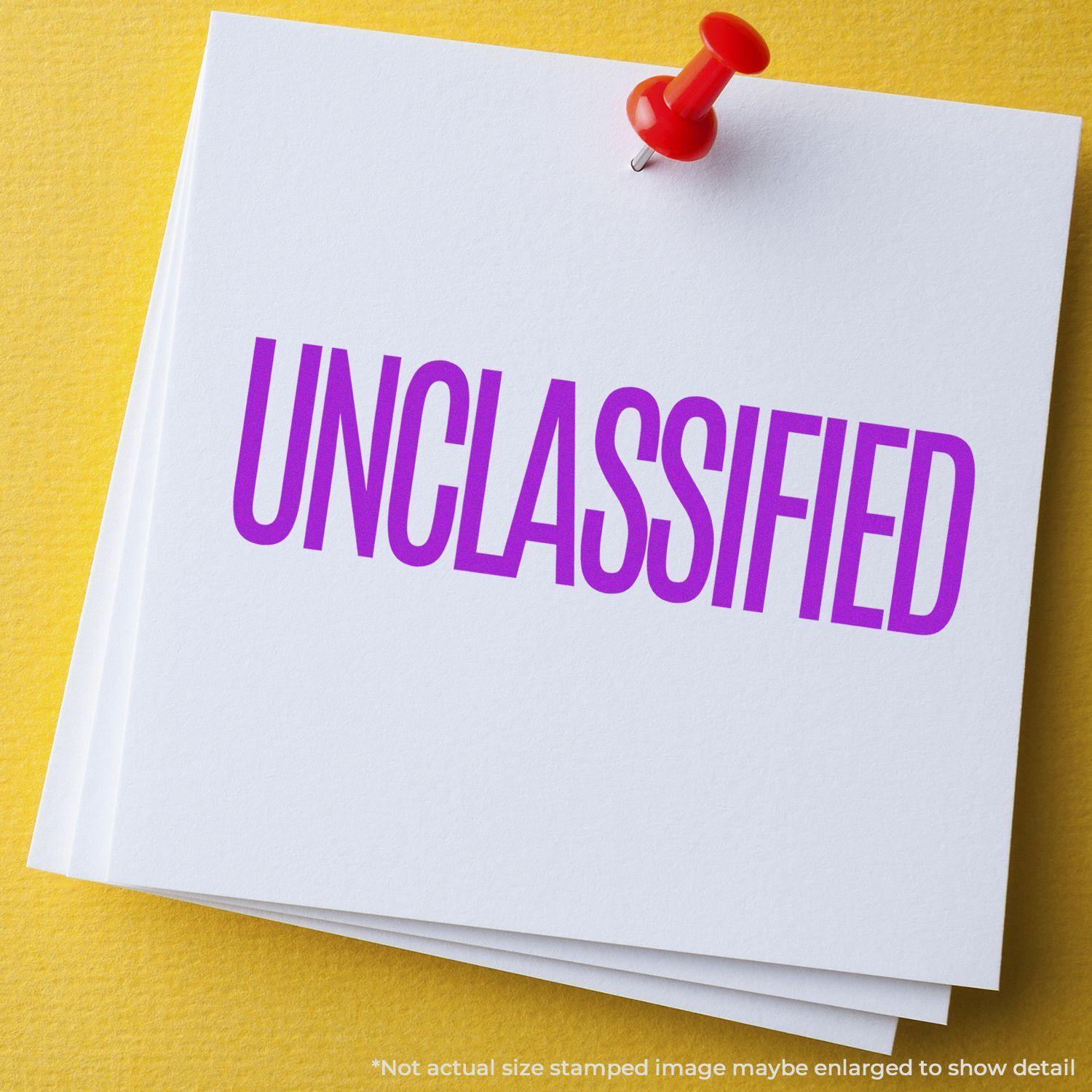 Large Self Inking Unclassified Stamp in purple ink on white paper with a red pushpin, placed on a yellow background.