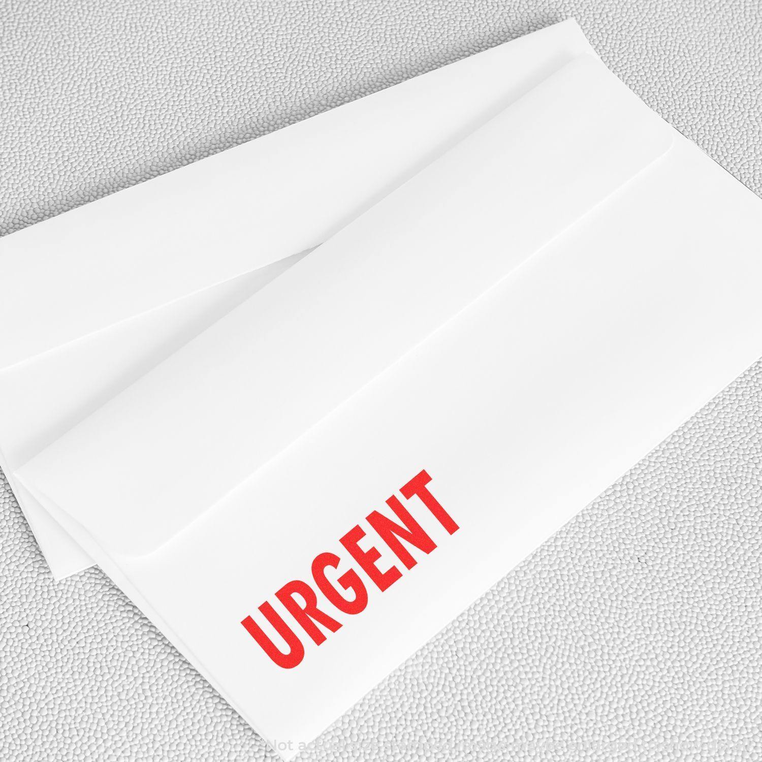 A self-inking stamp with a stamped image showing how the text "URGENT" in a large bold font is displayed by it.