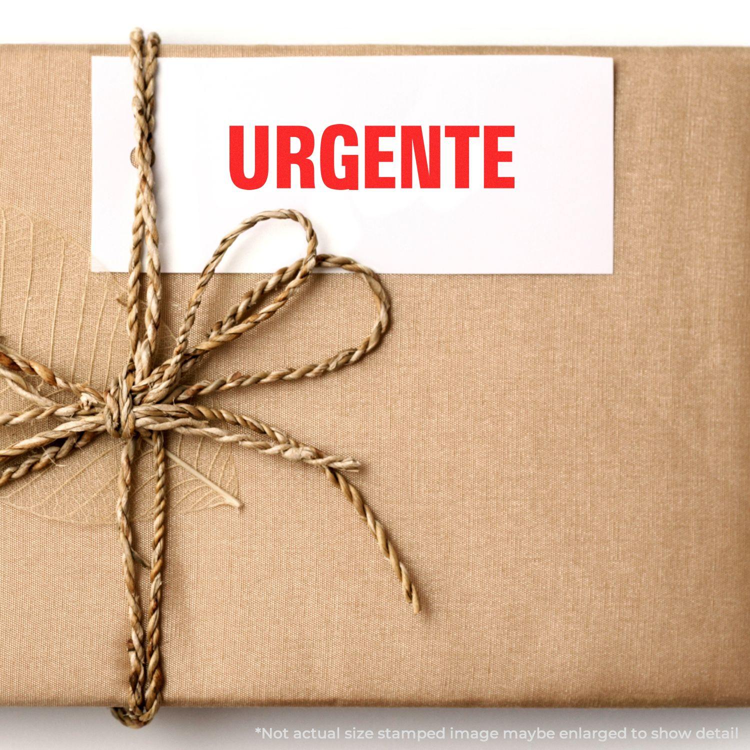 A brown package tied with twine, featuring a white card stamped with URGENTE in red using the Self Inking Urgente Stamp.