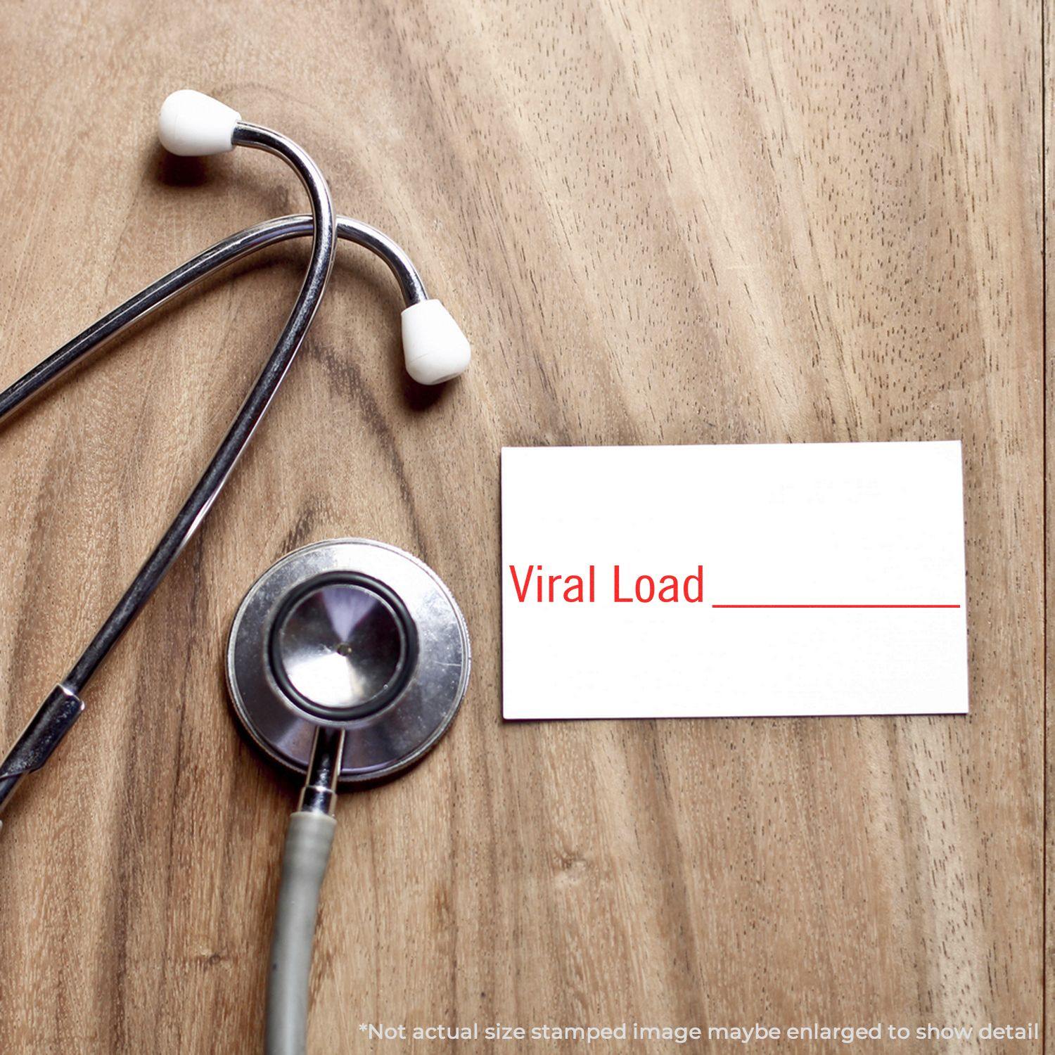 Stethoscope on wooden surface next to a card stamped with Viral Load in red, indicating a large viral load.